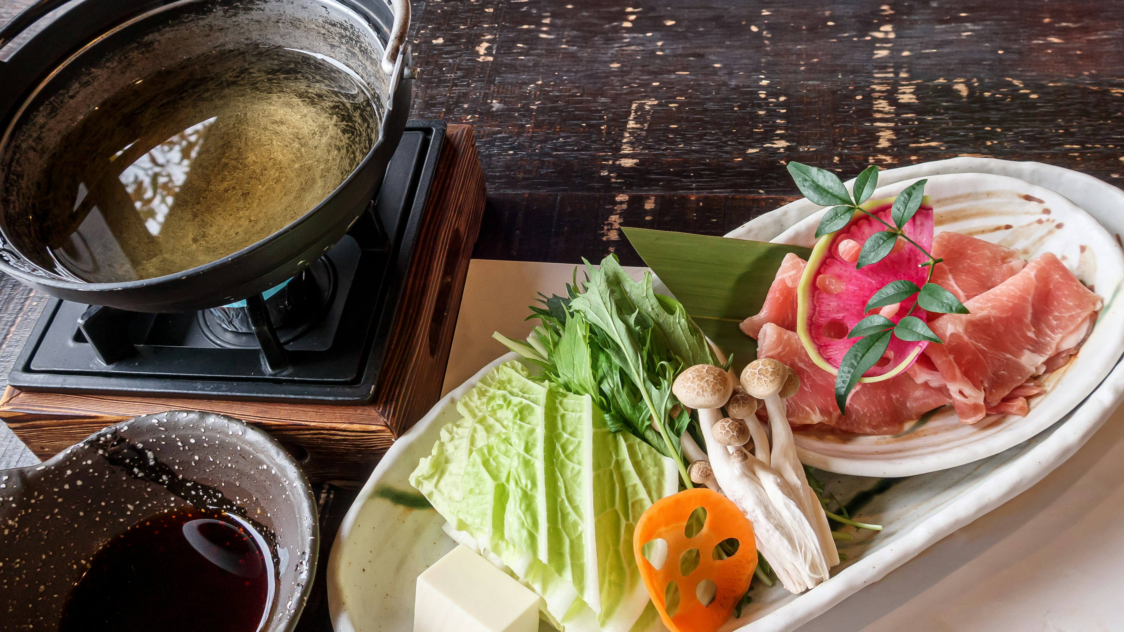 鍋料理の具材とスープが並ぶ美しいプレート