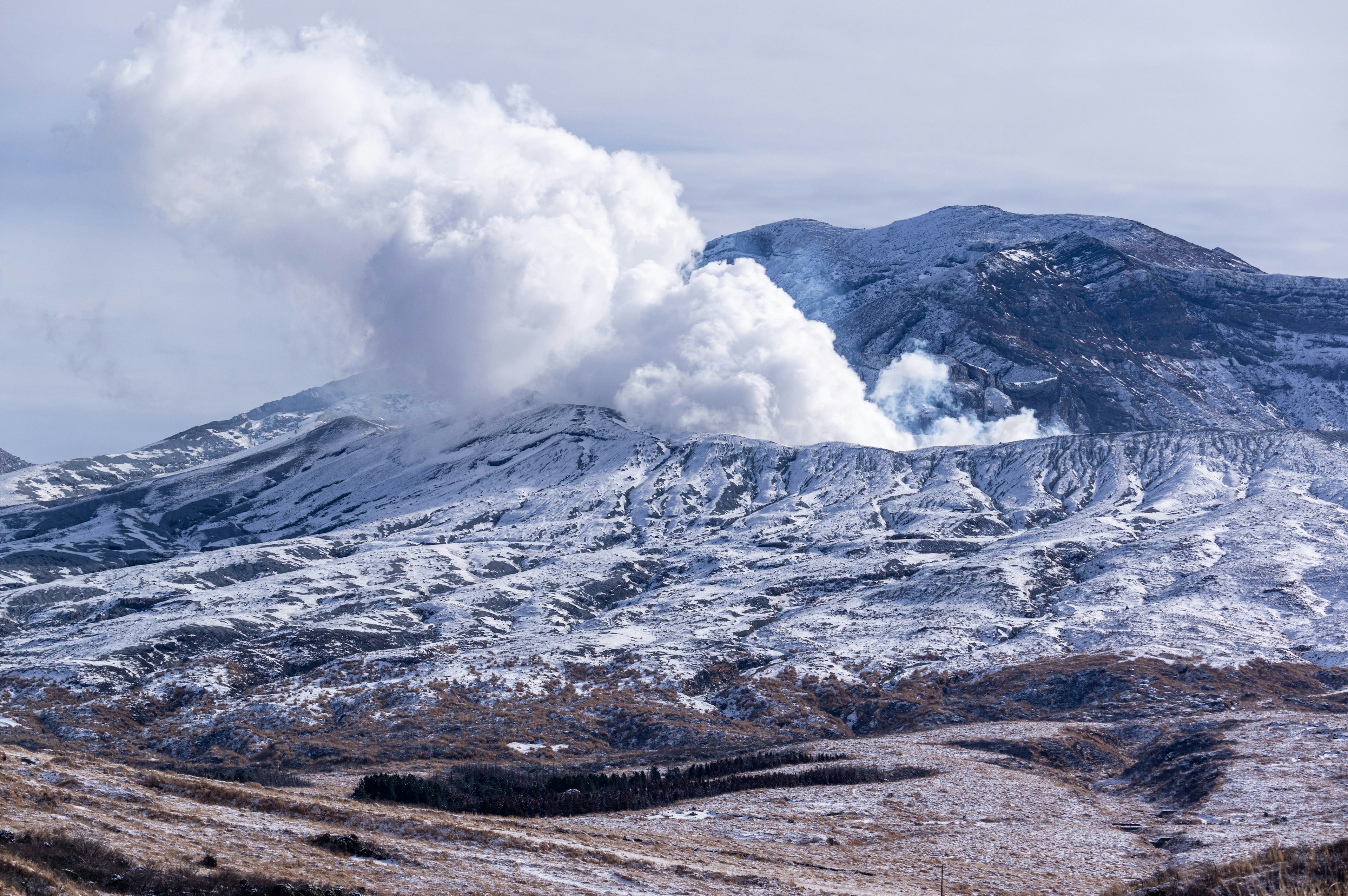 Schneebedeckter Berg mit vulkanischen Aschewolken