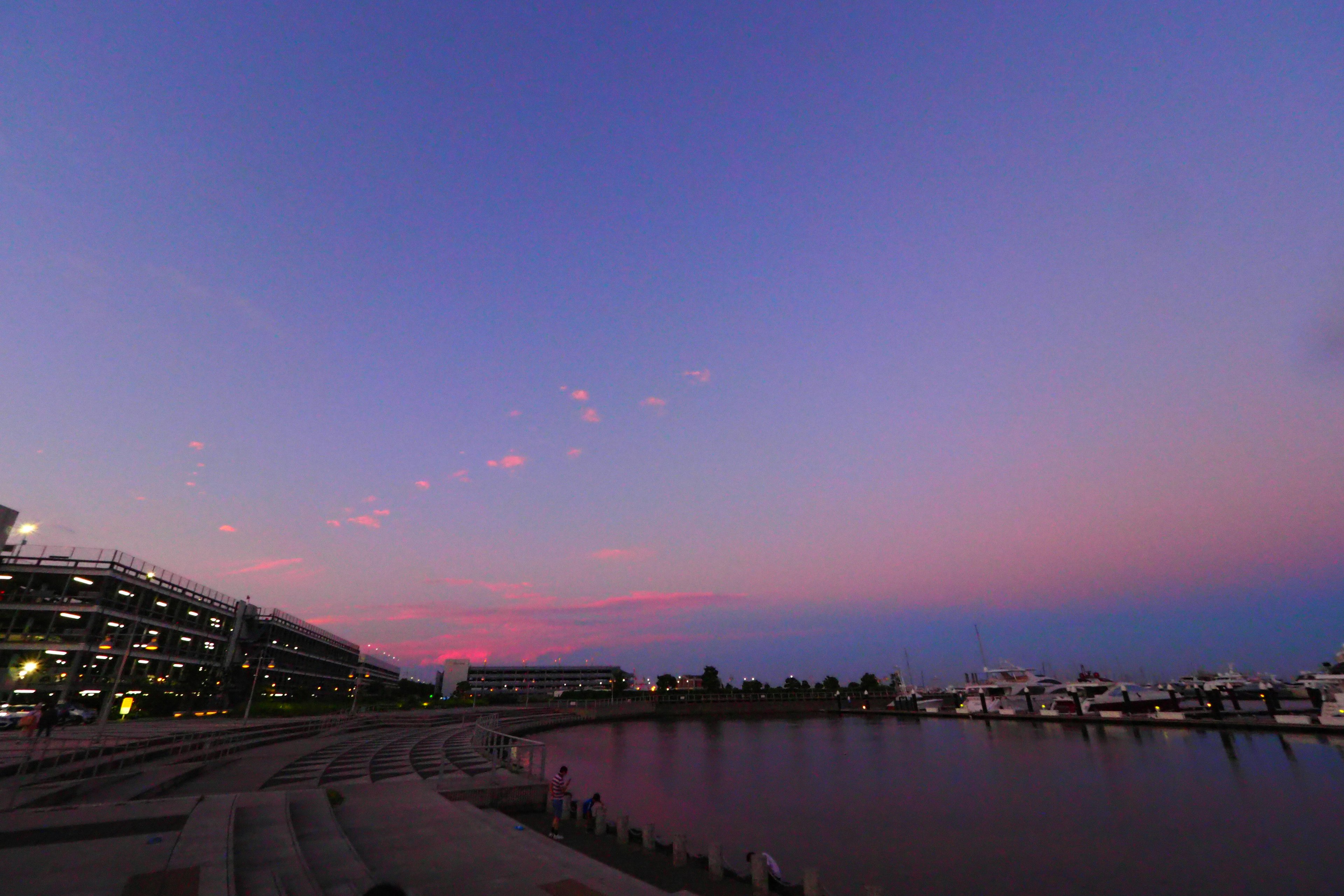 Vista panoramica di un porto al tramonto con cielo colorato e acqua calma