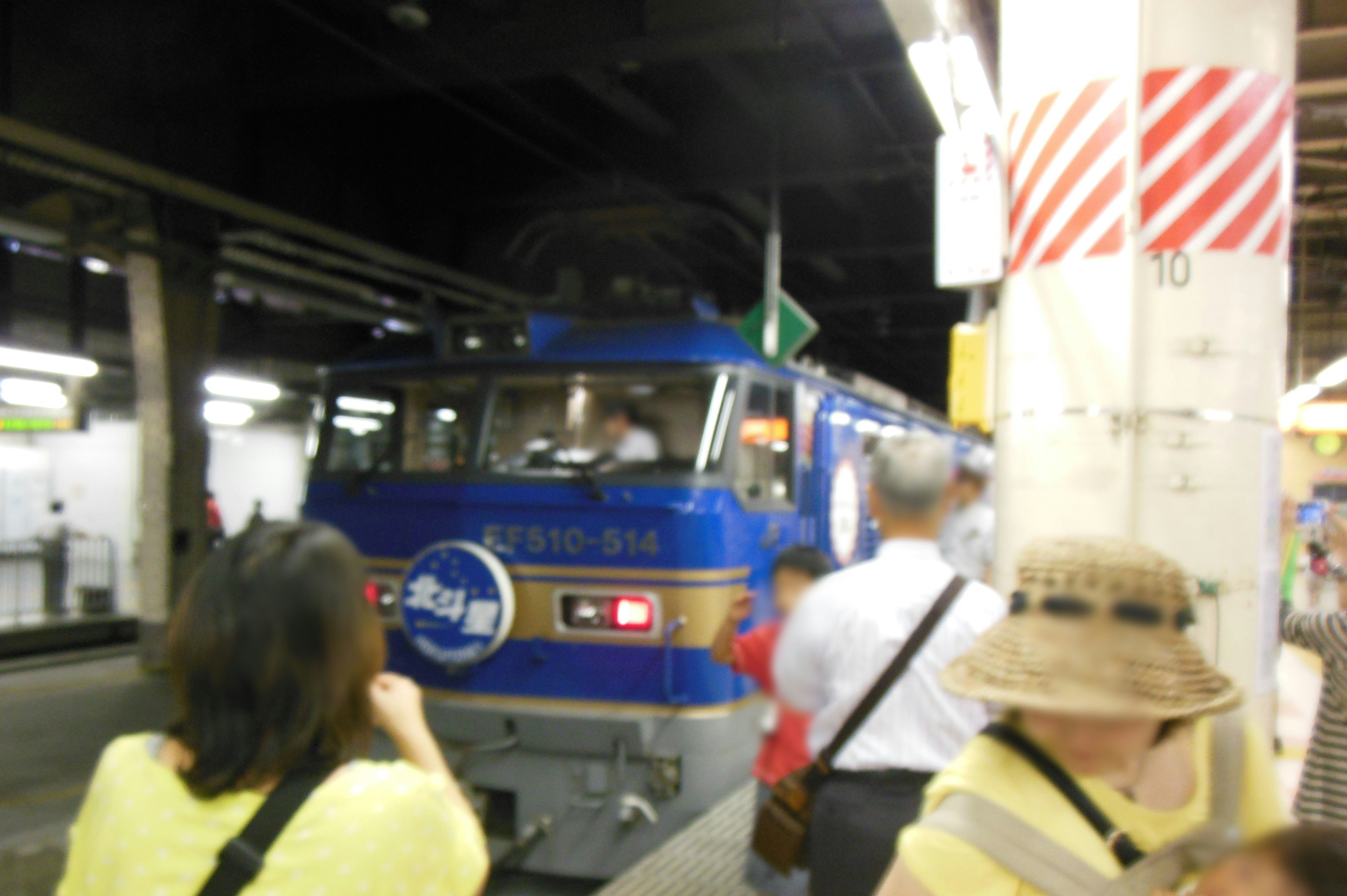 รถไฟสีน้ำเงินมาถึงสถานีพร้อมผู้โดยสารรอบข้าง