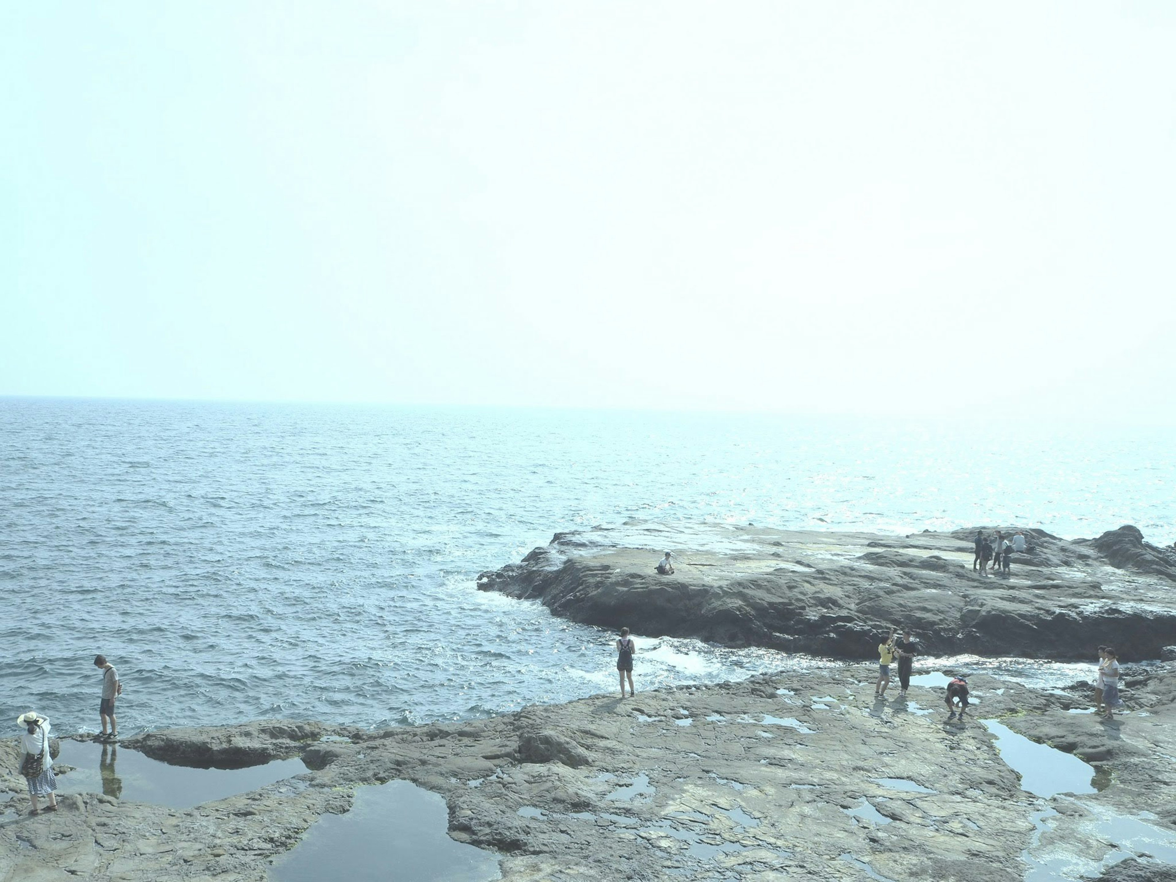 Personnes sur une plage rocheuse avec une vue magnifique sur l'océan