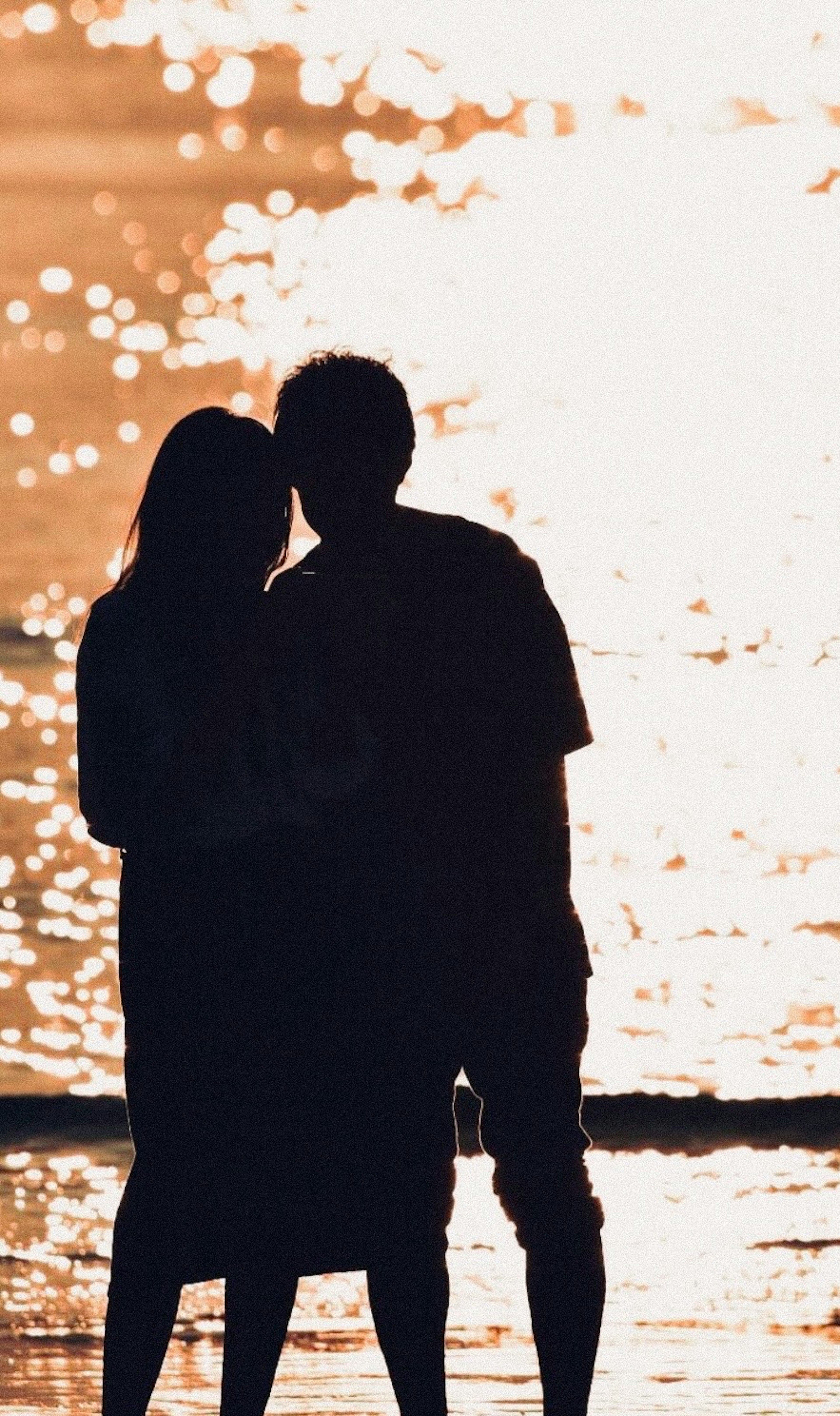 Silhouette of a couple against a sunset background