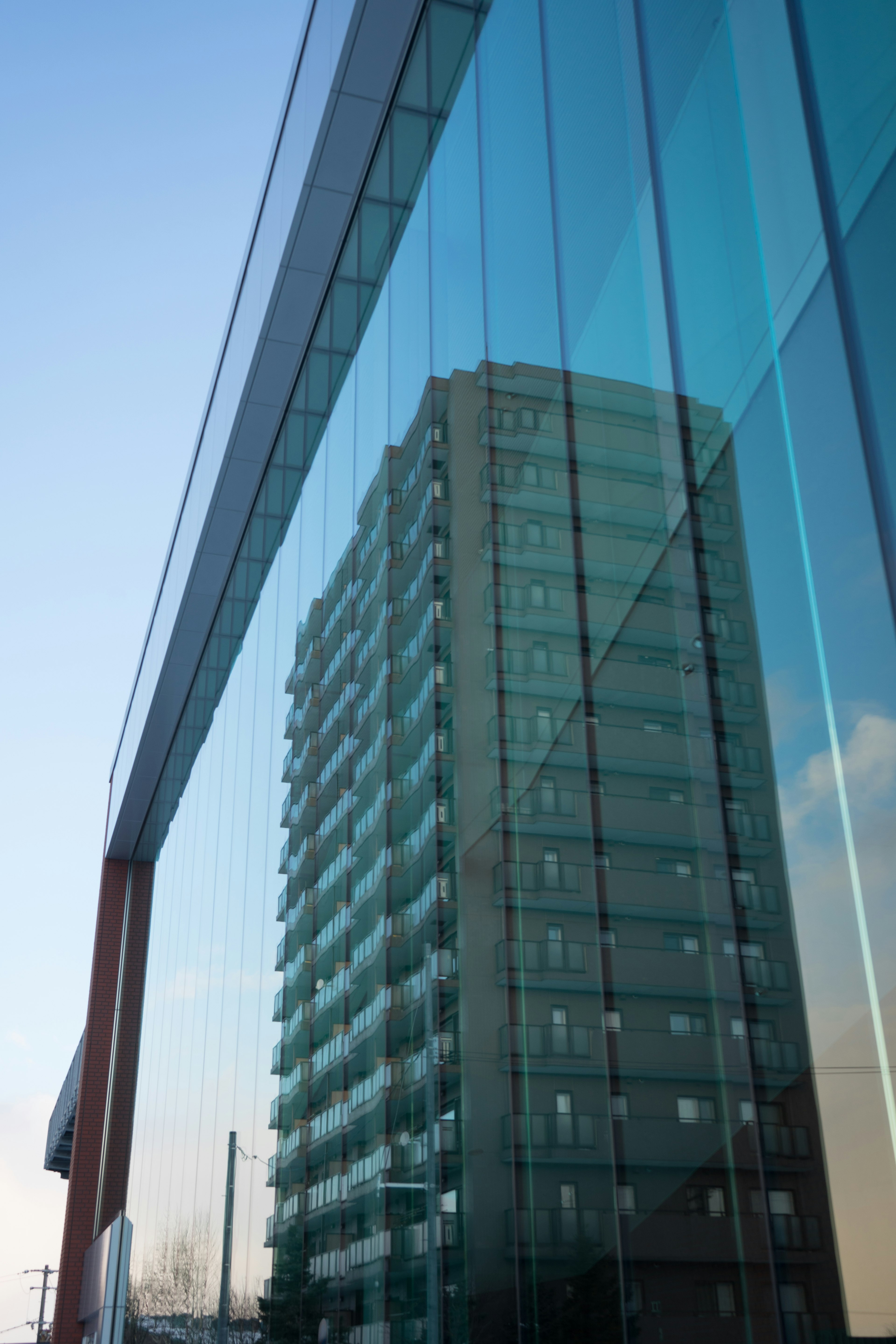 Modern glass building reflecting another structure