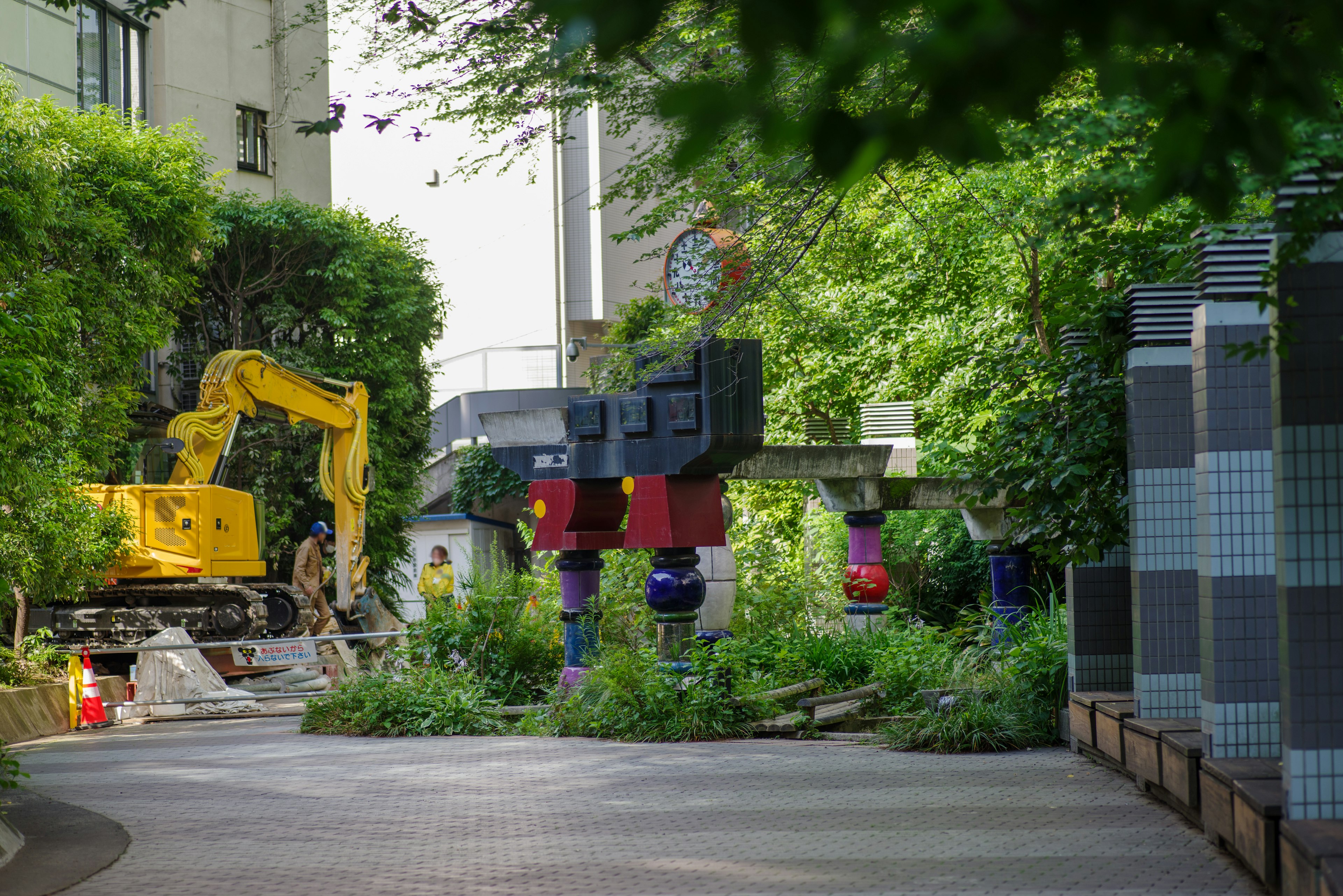 緑に囲まれた工事現場とカラフルな支柱のある風景