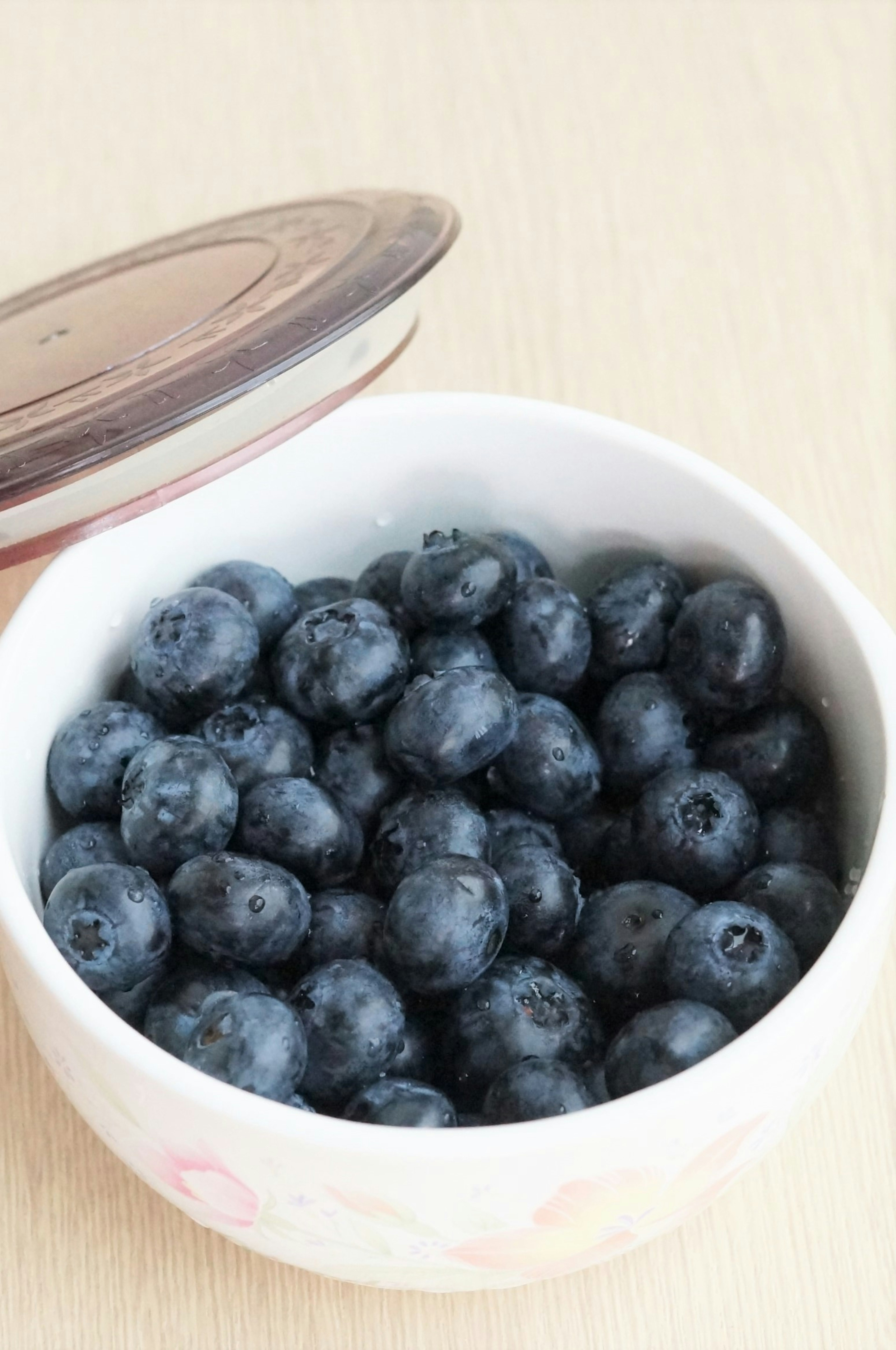 A white bowl filled with fresh blueberries