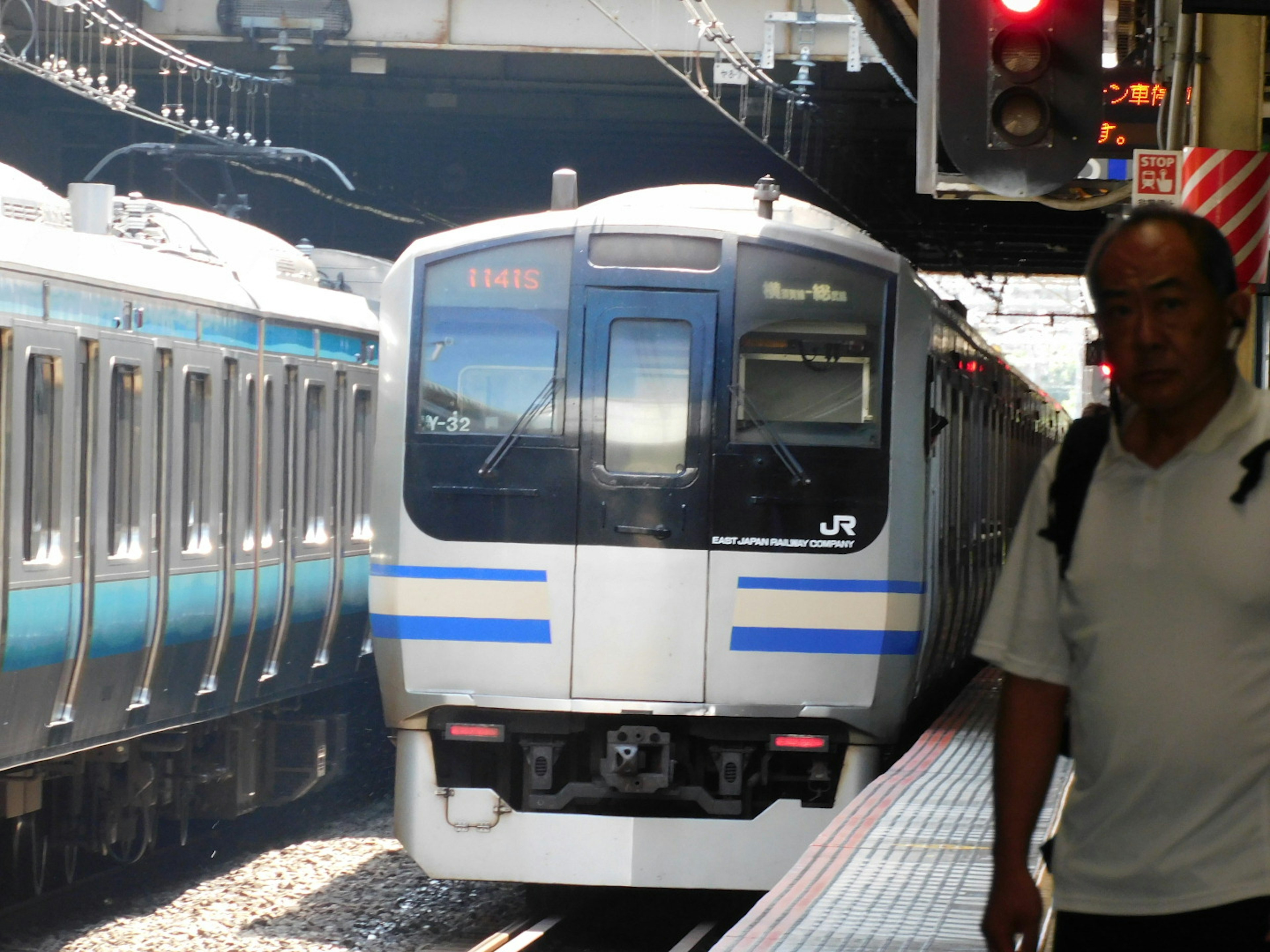 JR train stopped at the station with a passenger nearby