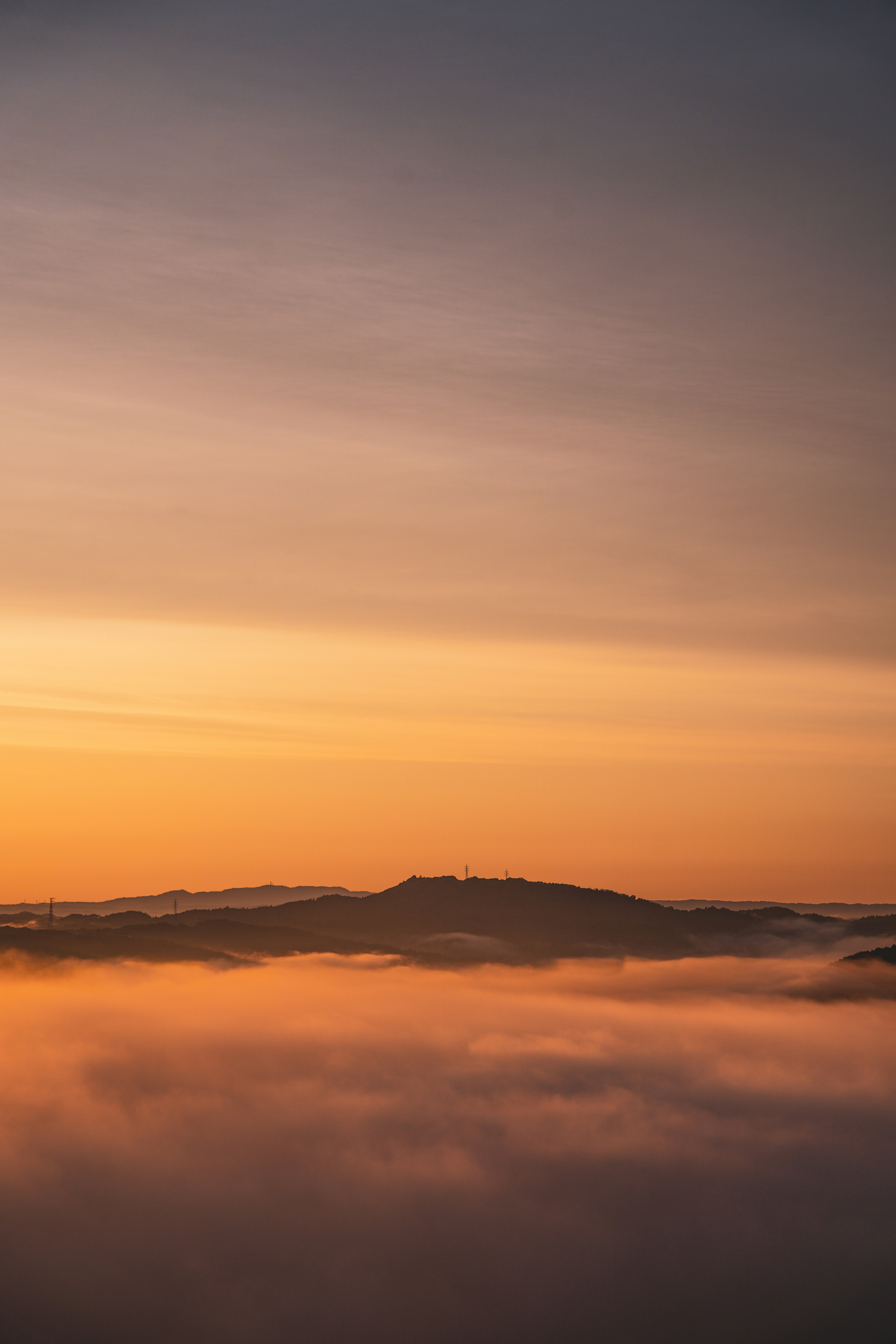 Montagne silhouettée contre un lever de soleil coloré au-dessus des nuages