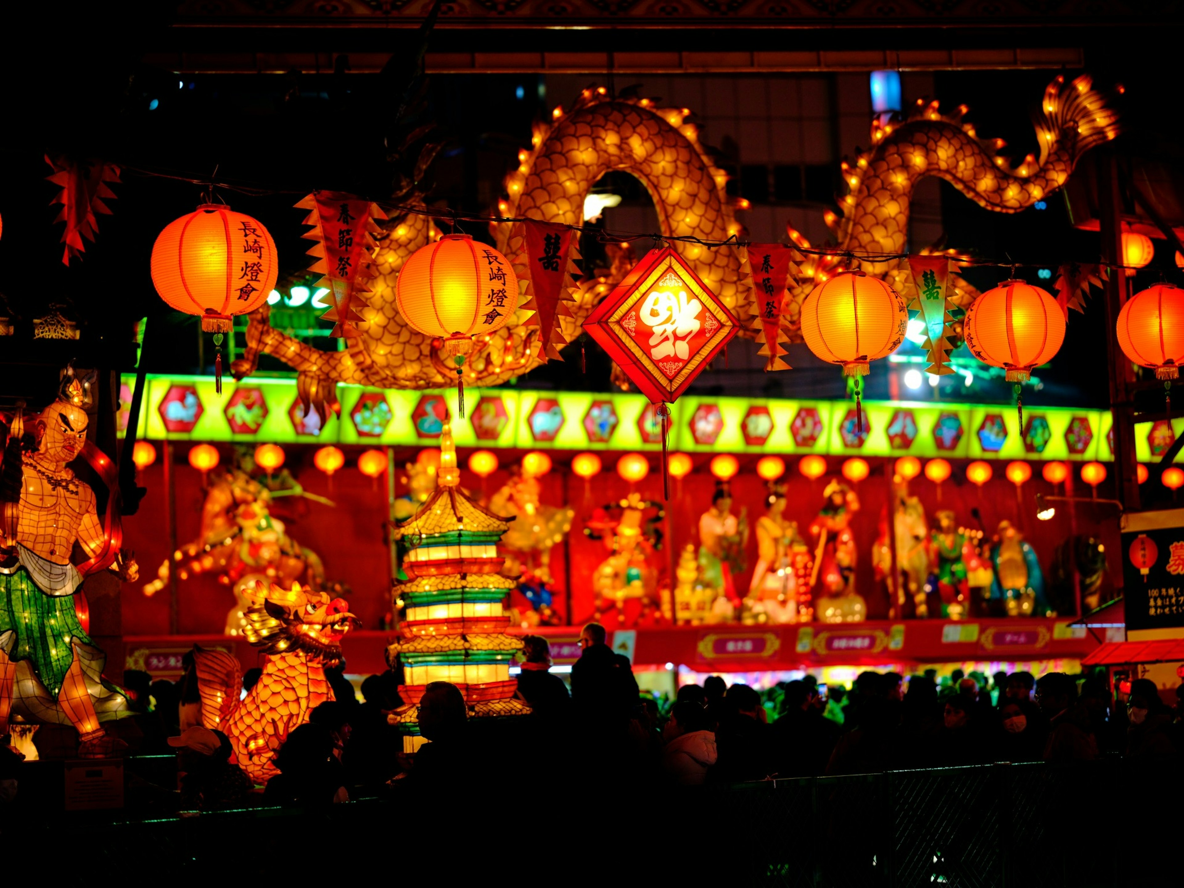 Colorful lanterns and decorated figures in a vibrant festival scene