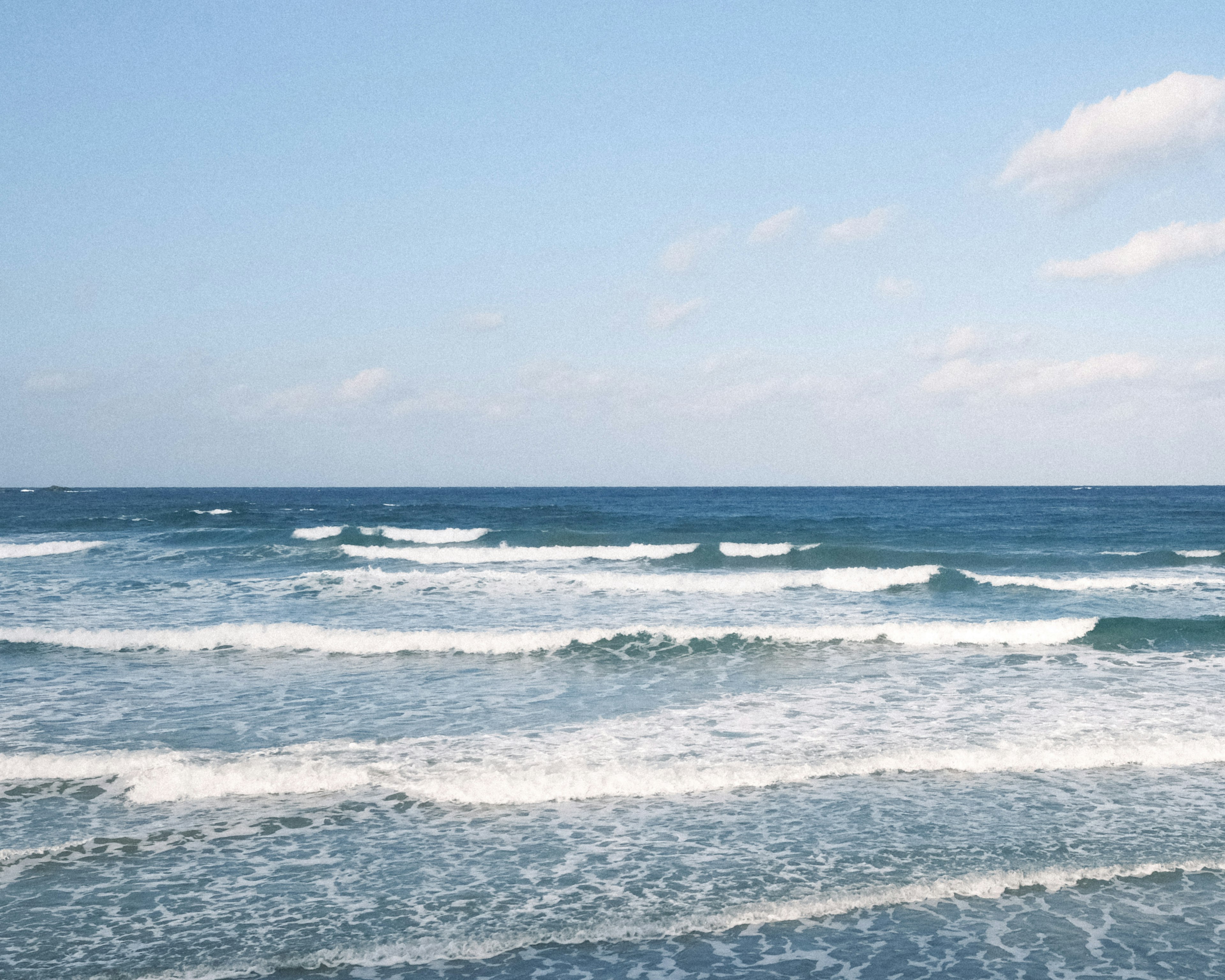 青い海と波が穏やかに打ち寄せる風景