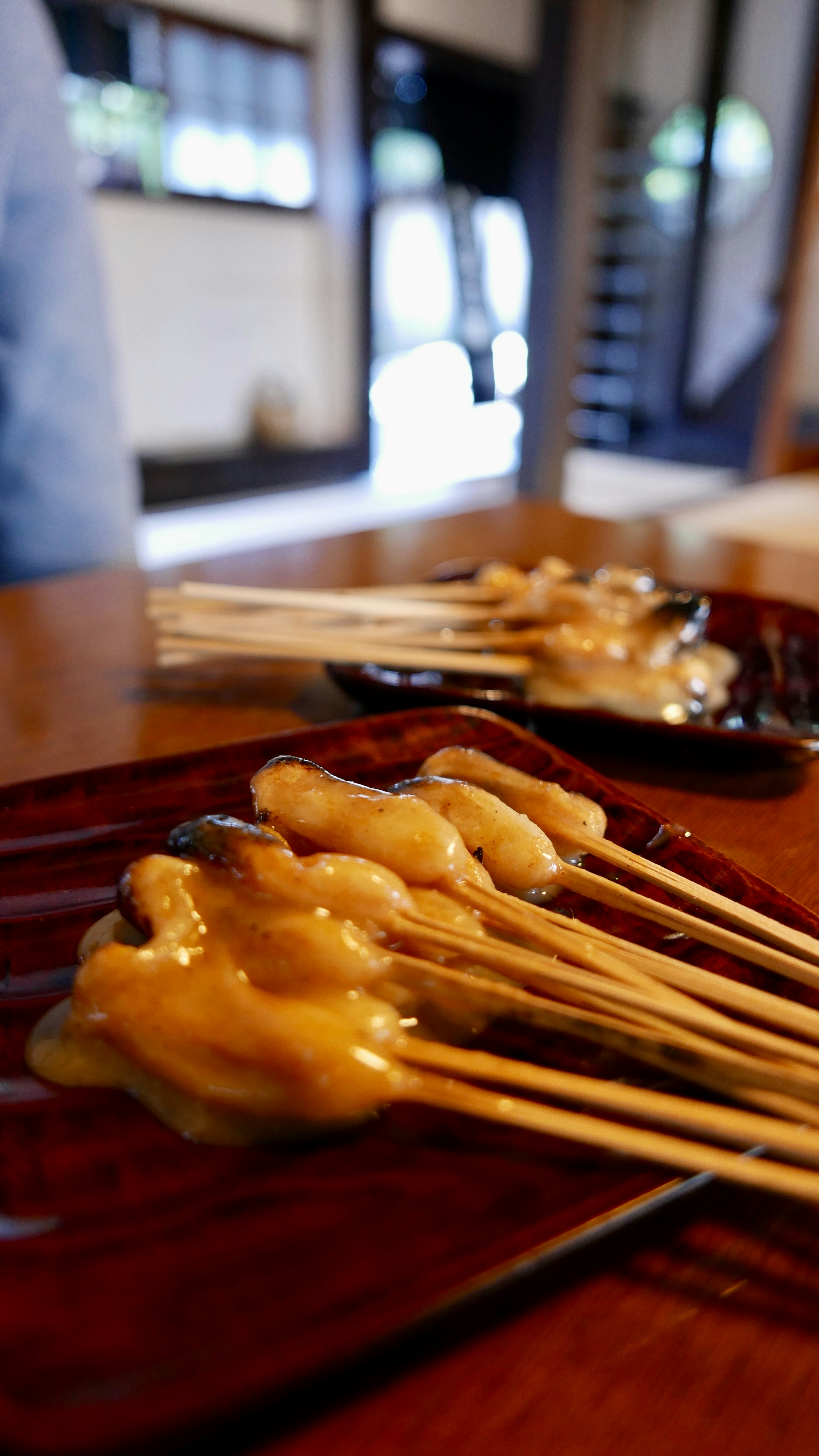 A close-up of grilled chicken skewers on a wooden table