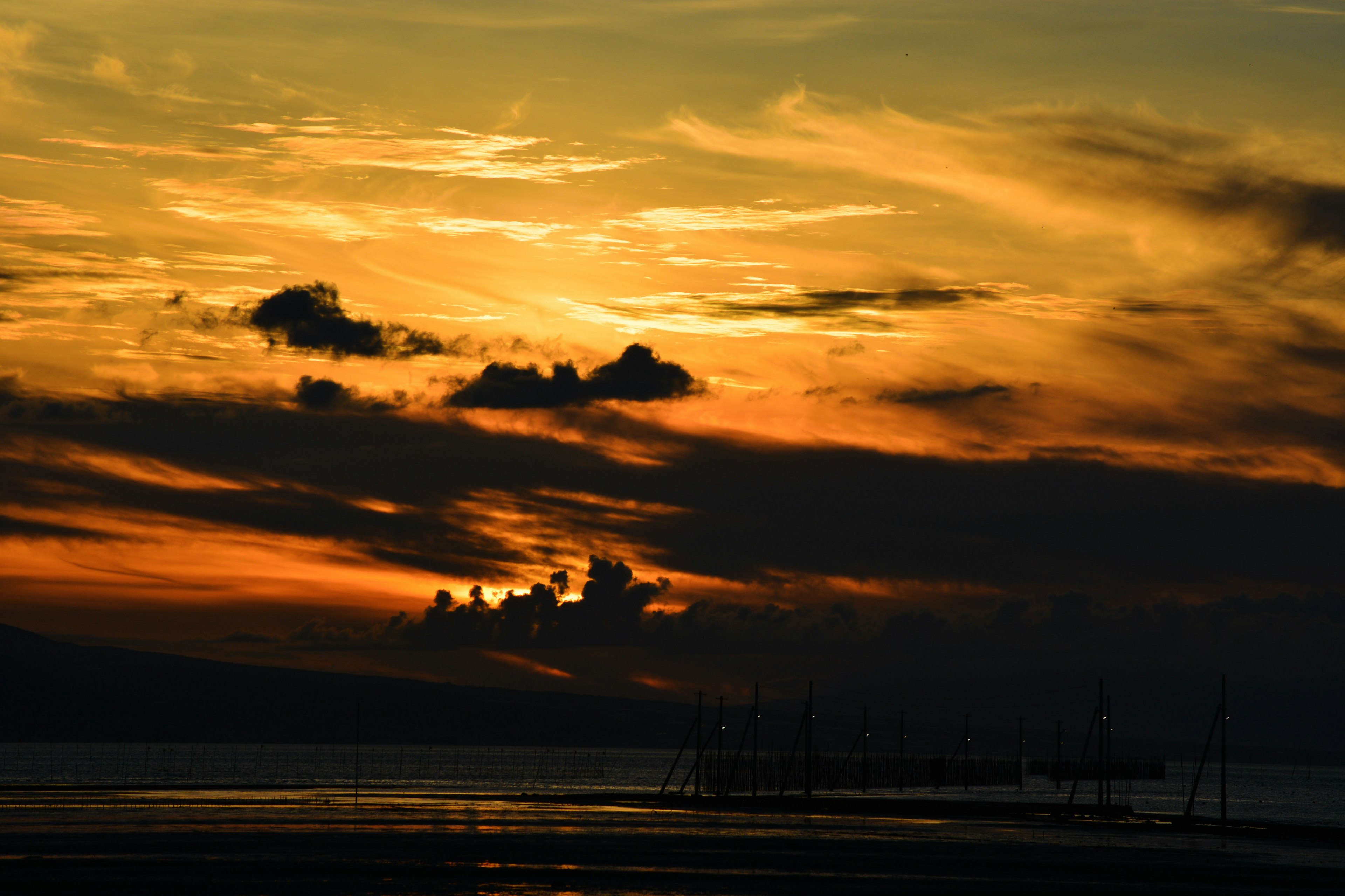 Hermoso cielo al atardecer con nubes y silueta del mar