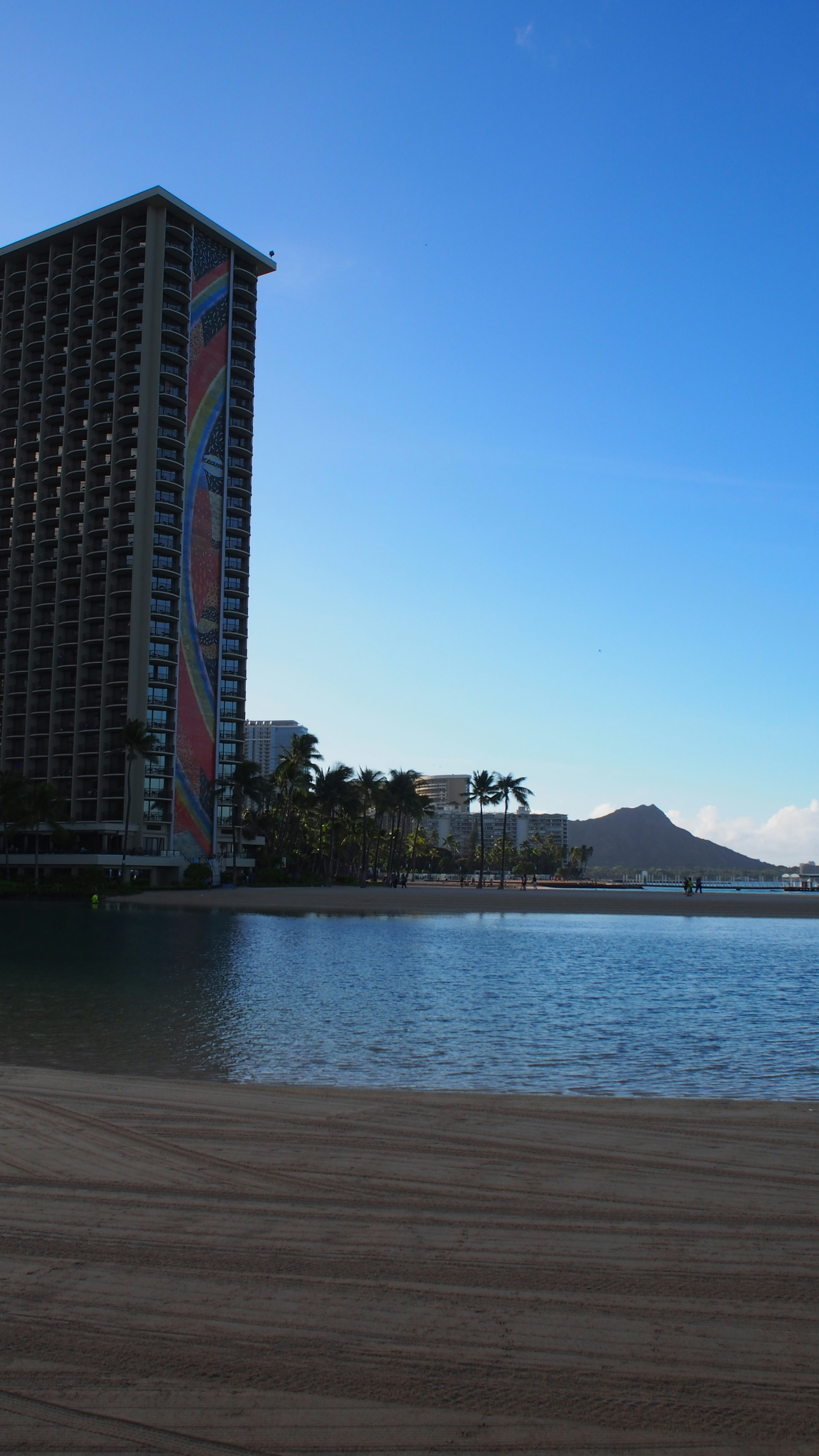 Coastal view featuring a high-rise building and a clear blue sky