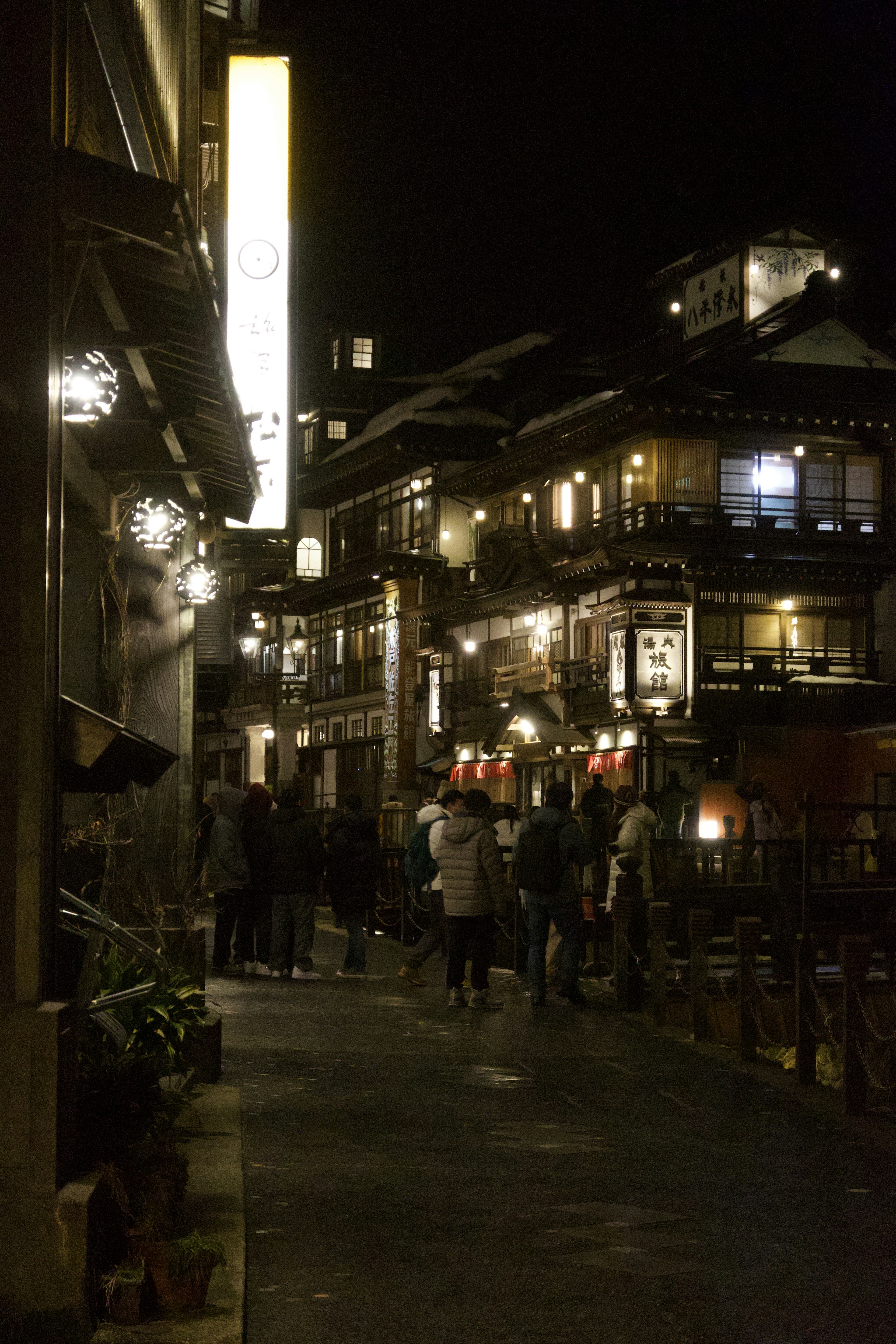 Vue nocturne de bâtiments traditionnels et rue animée