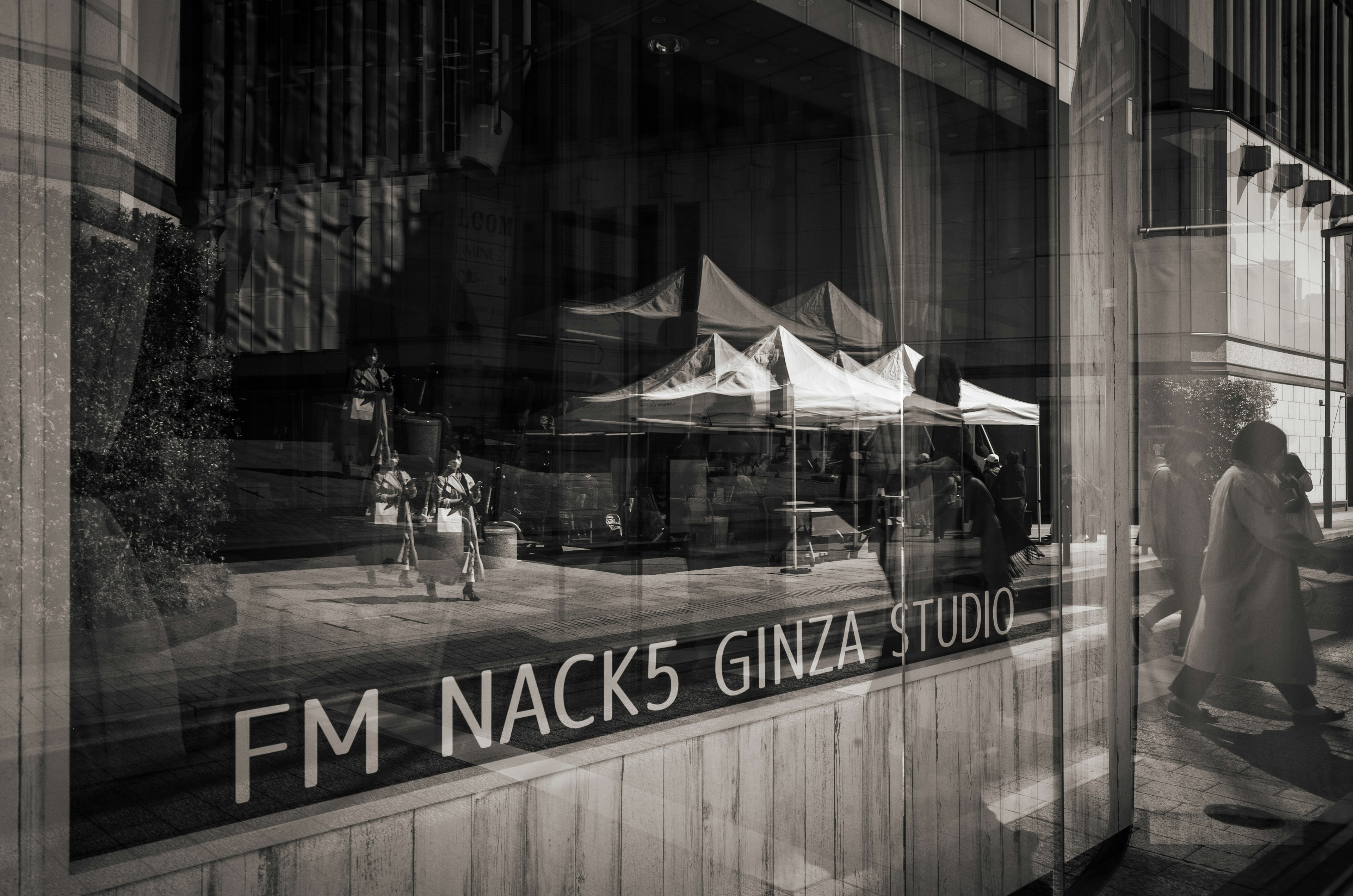 Cảnh FM NACK5 Ginza Studio qua cửa sổ với các lều và người