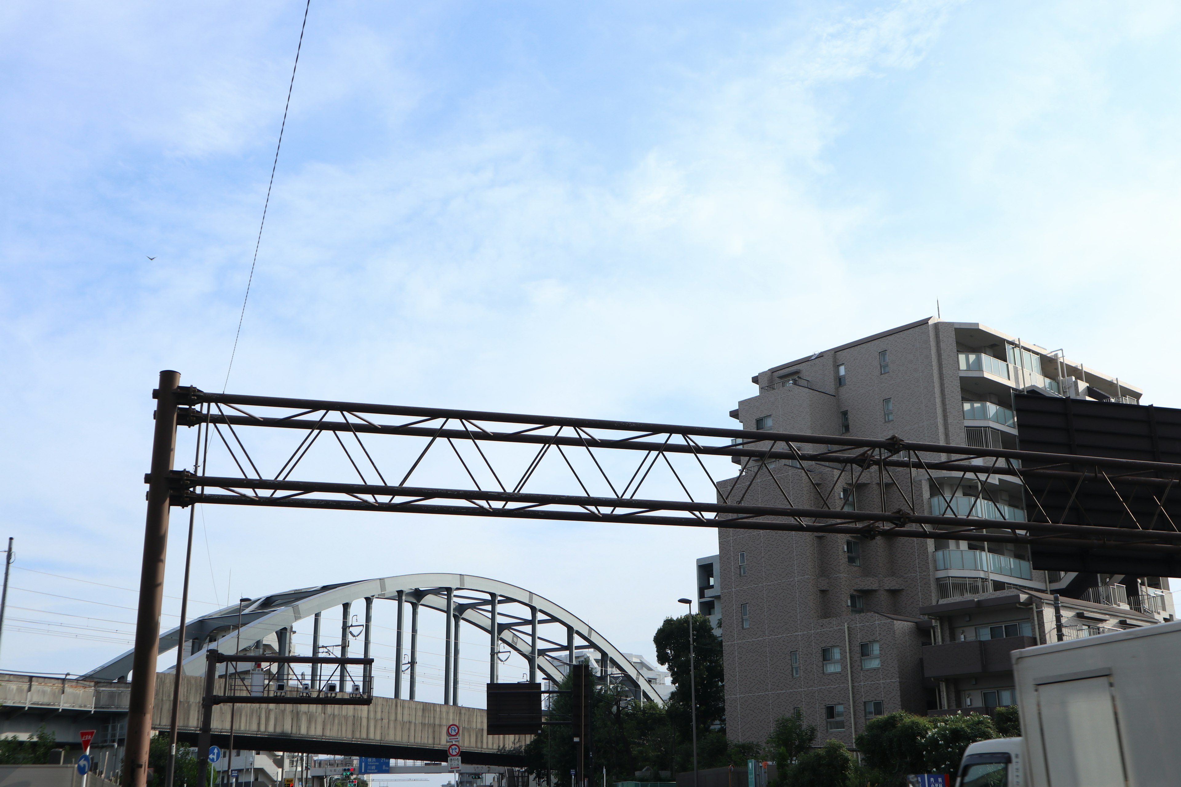 Pemandangan jembatan lengkung dan gedung tinggi di bawah langit biru