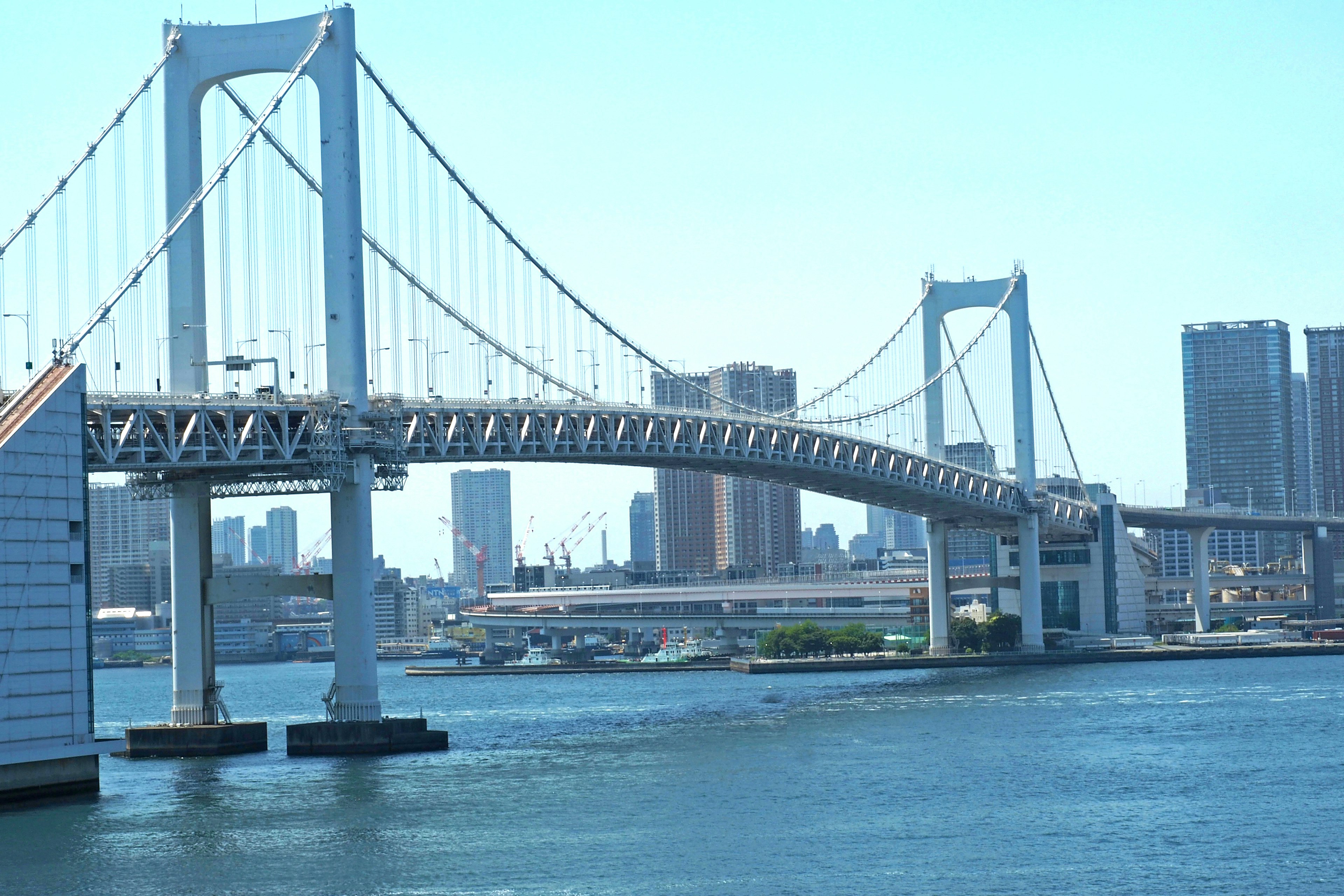 Blick auf die Rainbow Bridge mit blauem Himmel und Stadtsilhouette