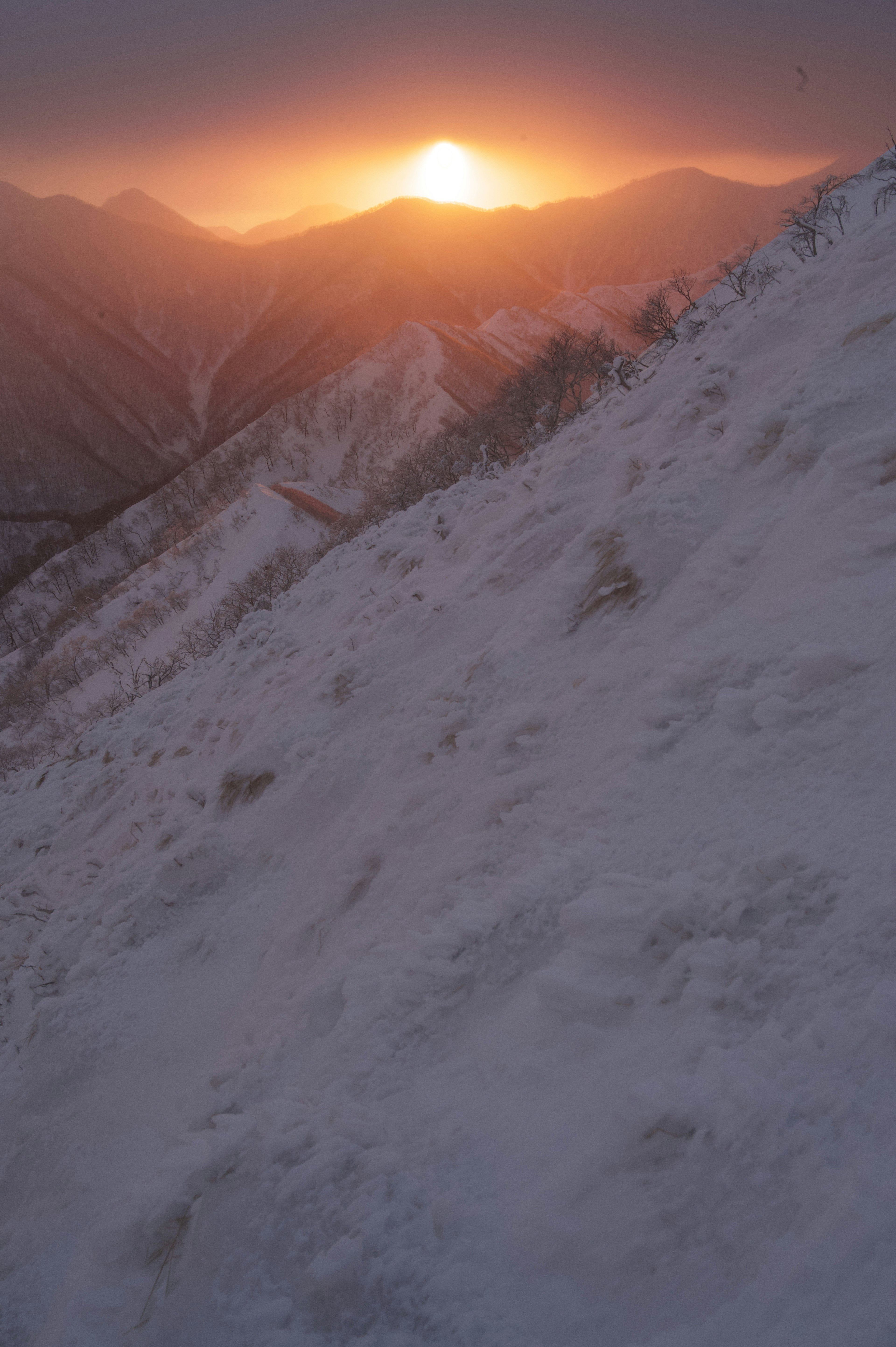 雪覆盖的山坡上的日落