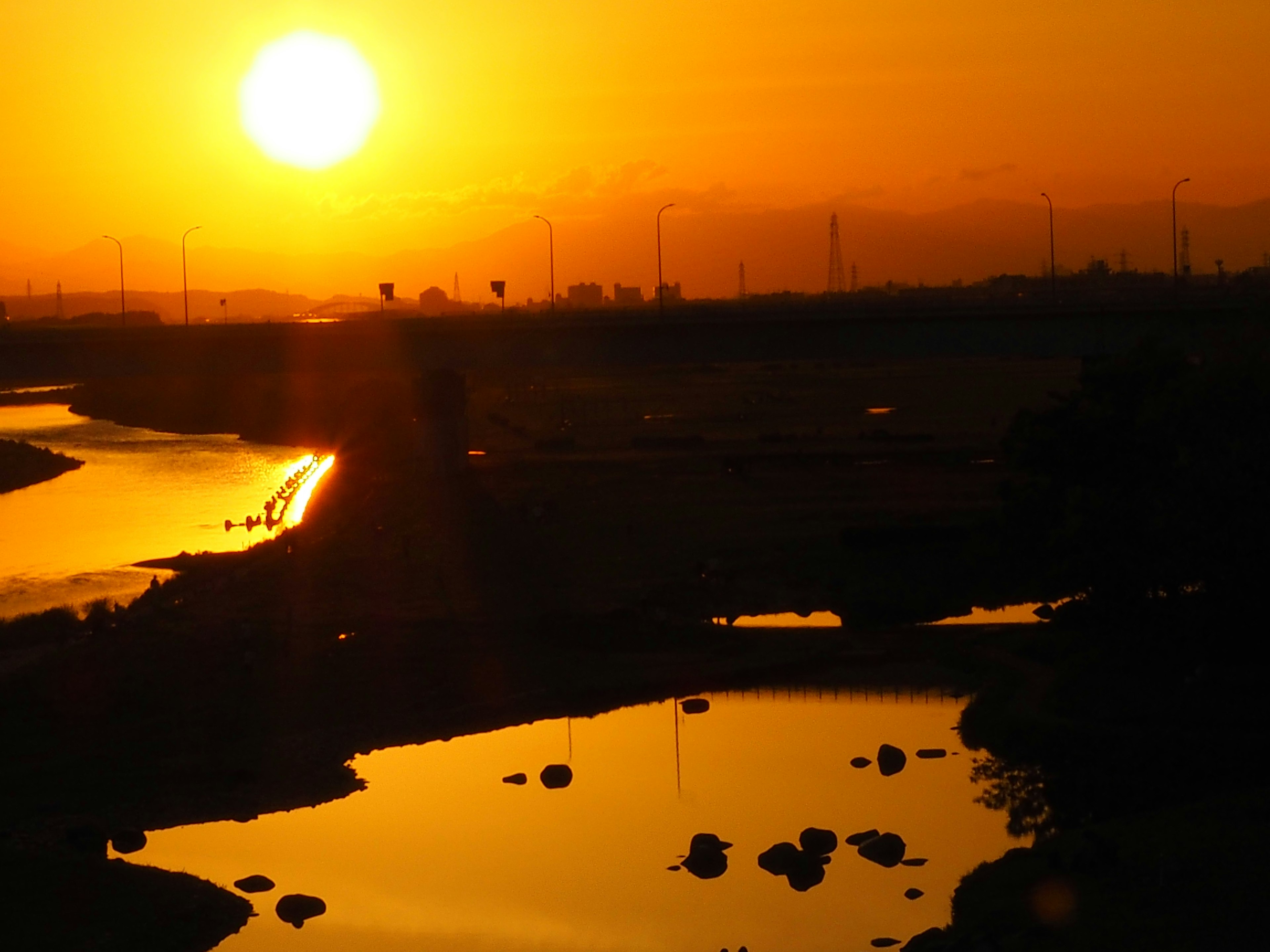 Pemandangan indah dengan matahari terbenam yang memantul di sungai