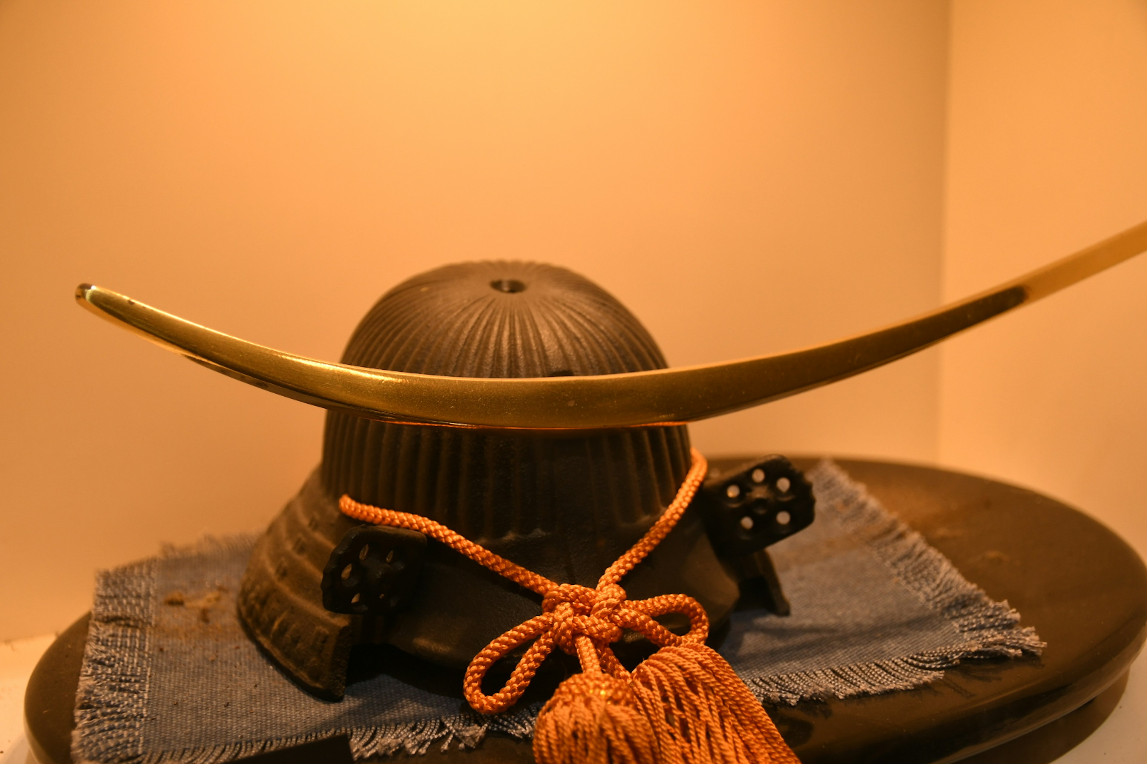 Un casque noir traditionnel avec une épée dorée courbée exposée avec élégance