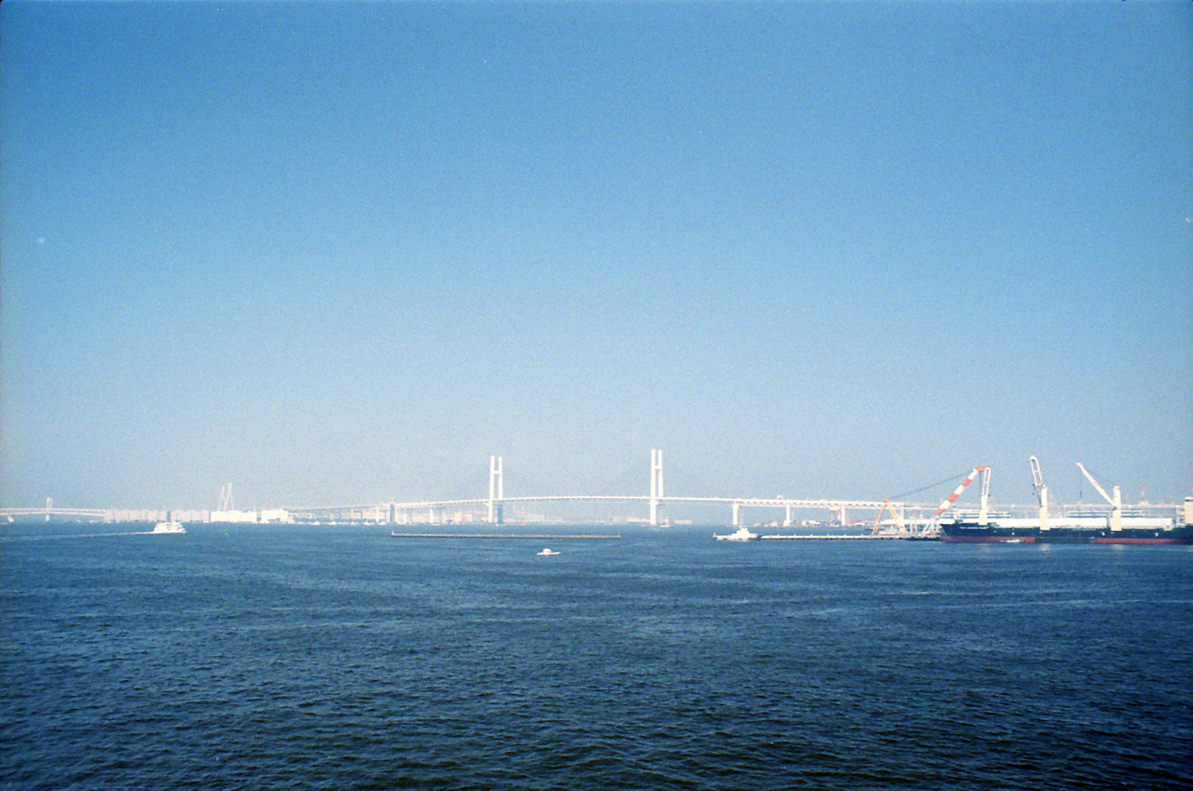 Malersicher Blick auf eine Brücke und Boote unter klarem blauen Himmel