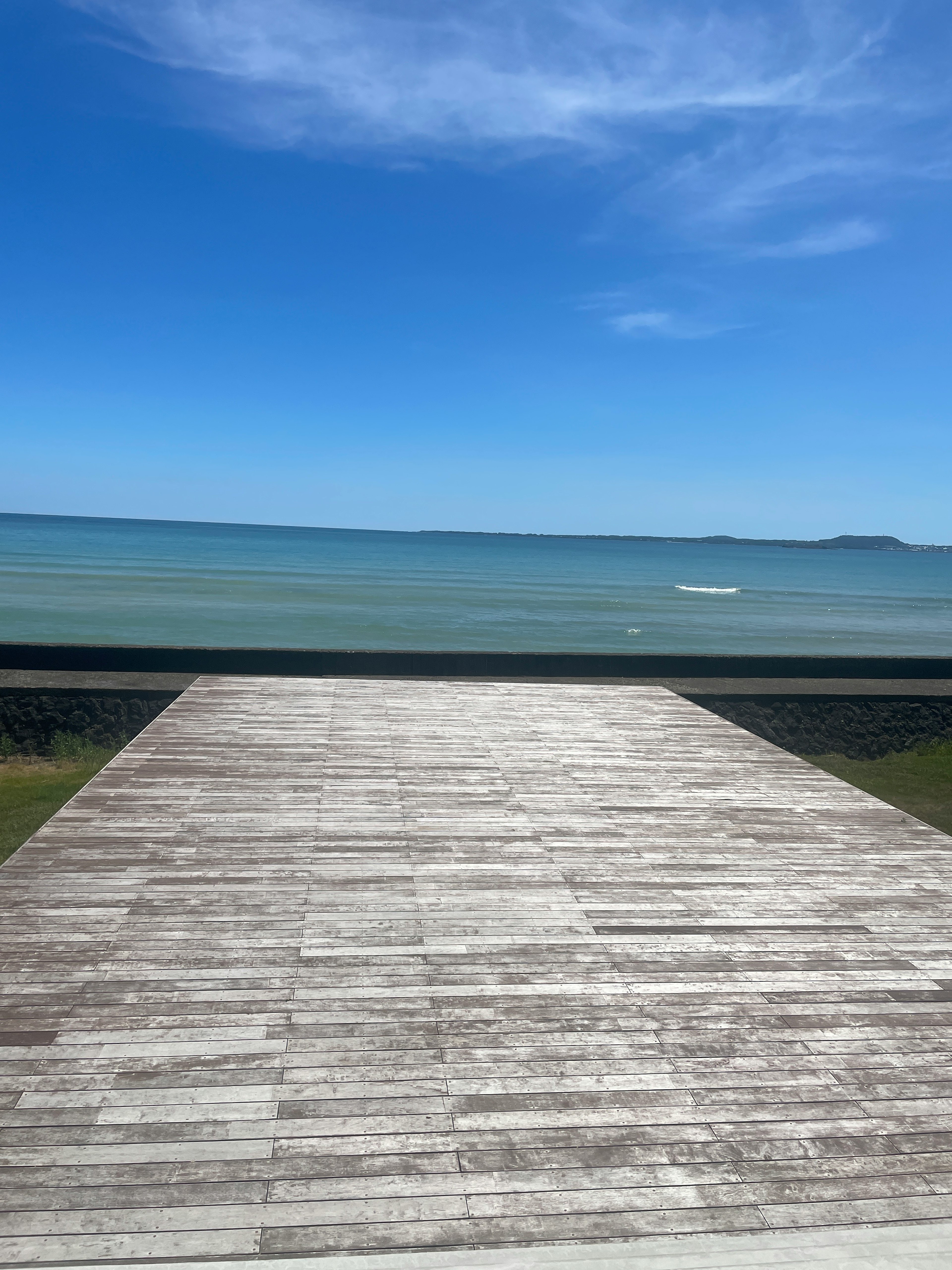 Wooden deck overlooking calm sea and blue sky