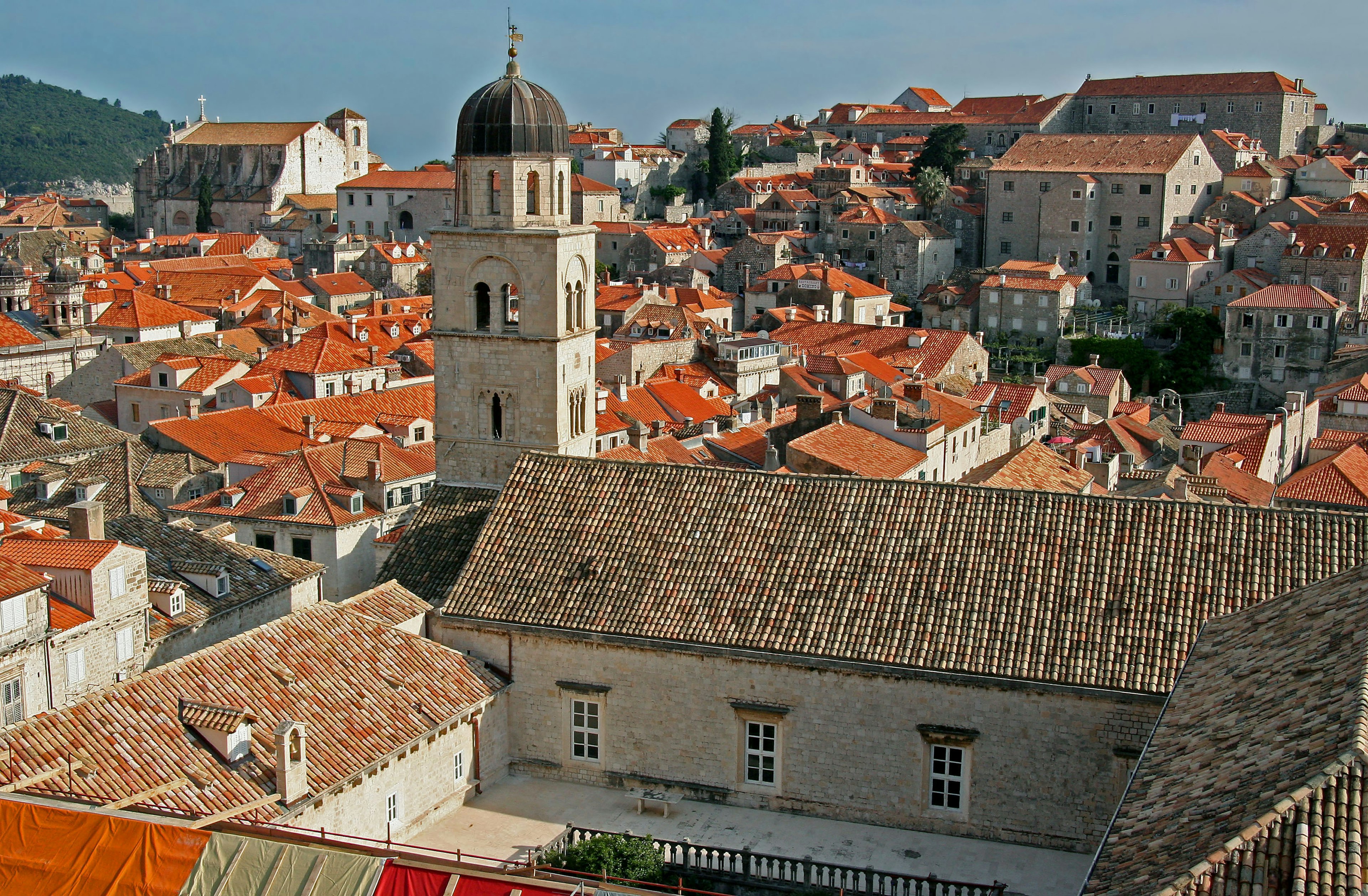 Panoramablick auf eine historische Stadt mit roten Dächern und einem Kirchturm