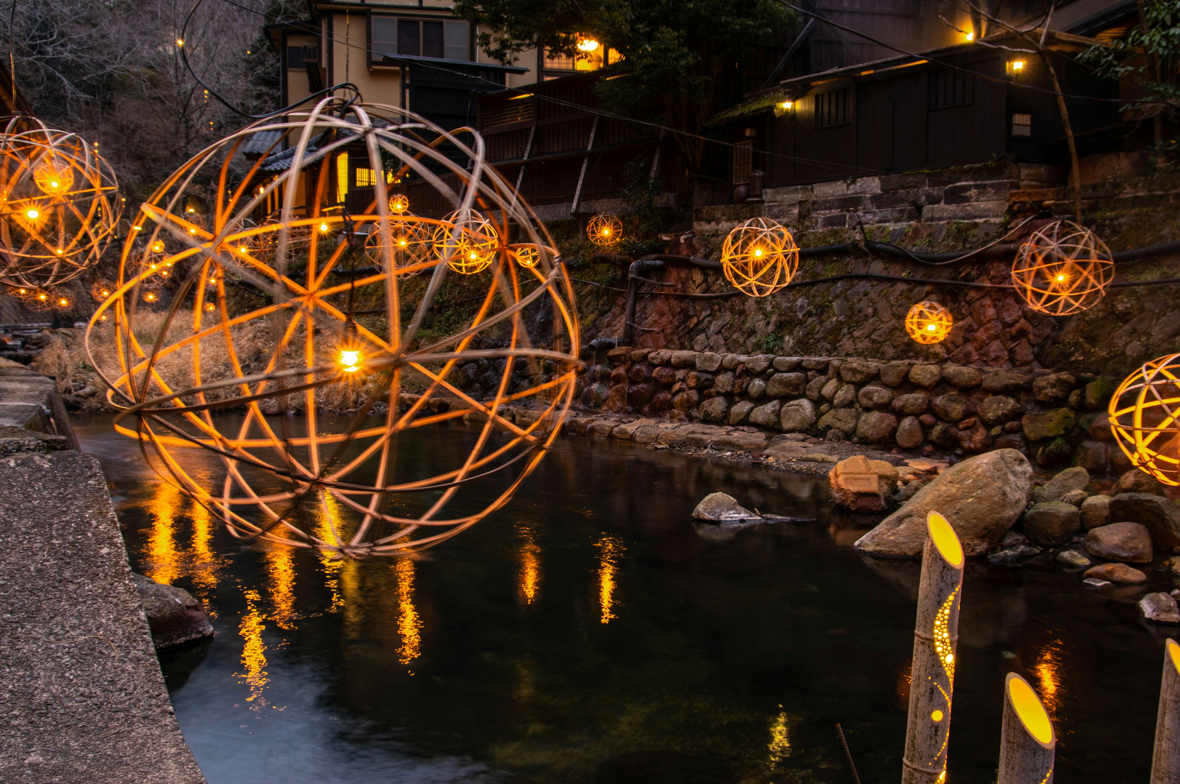 Beautiful spherical lanterns floating above the river with surrounding scenery