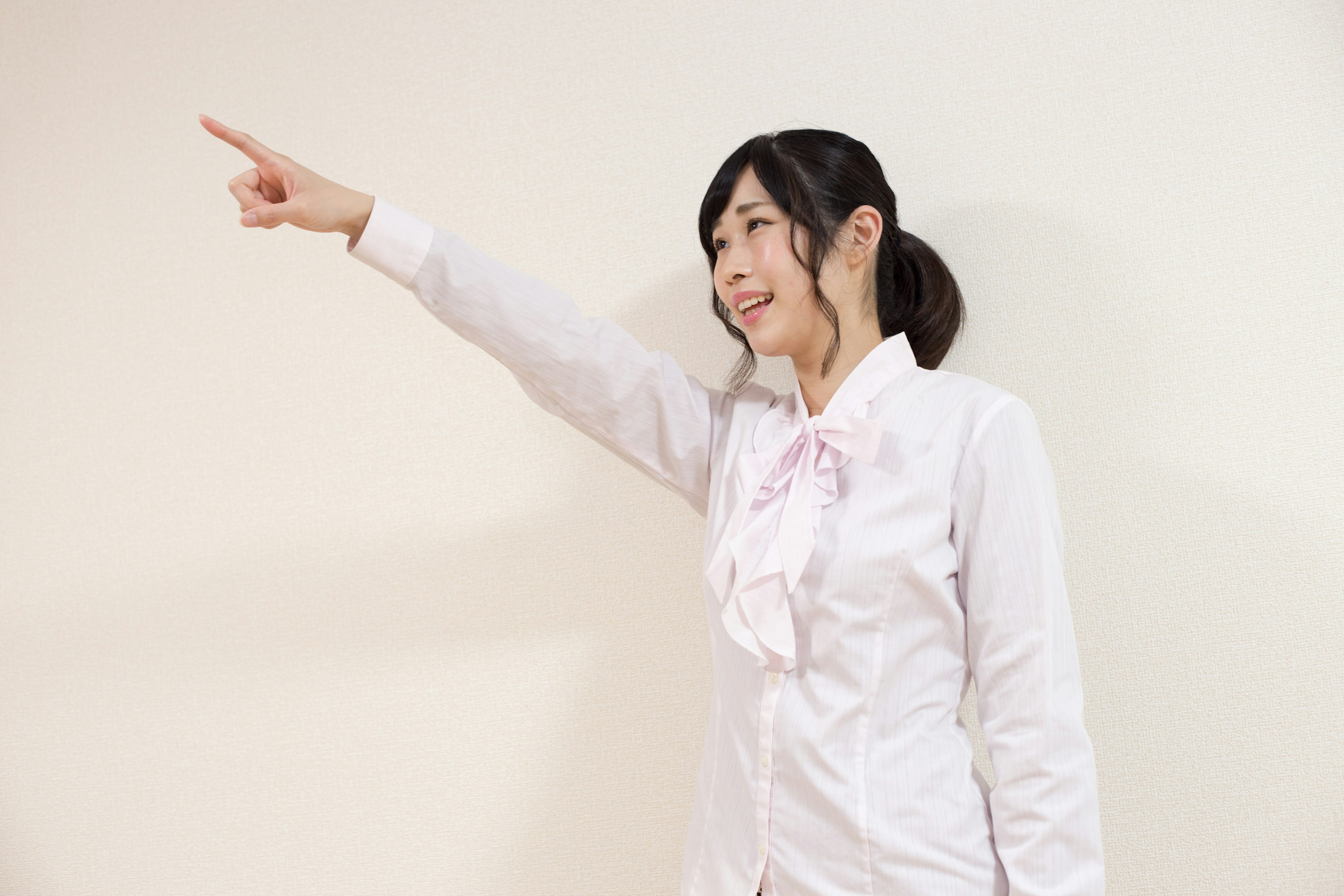 A woman in a white shirt pointing with her finger