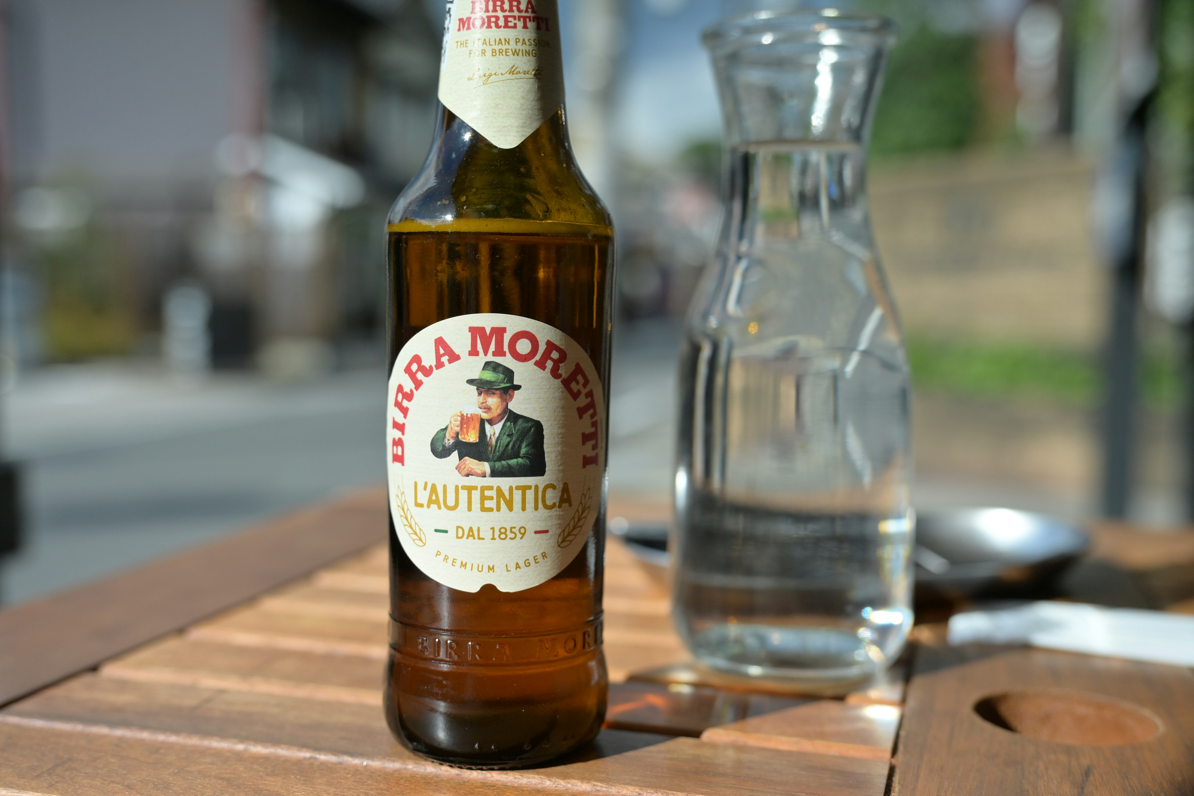 Une bouteille de bière et une carafe d'eau claire sur une table en bois