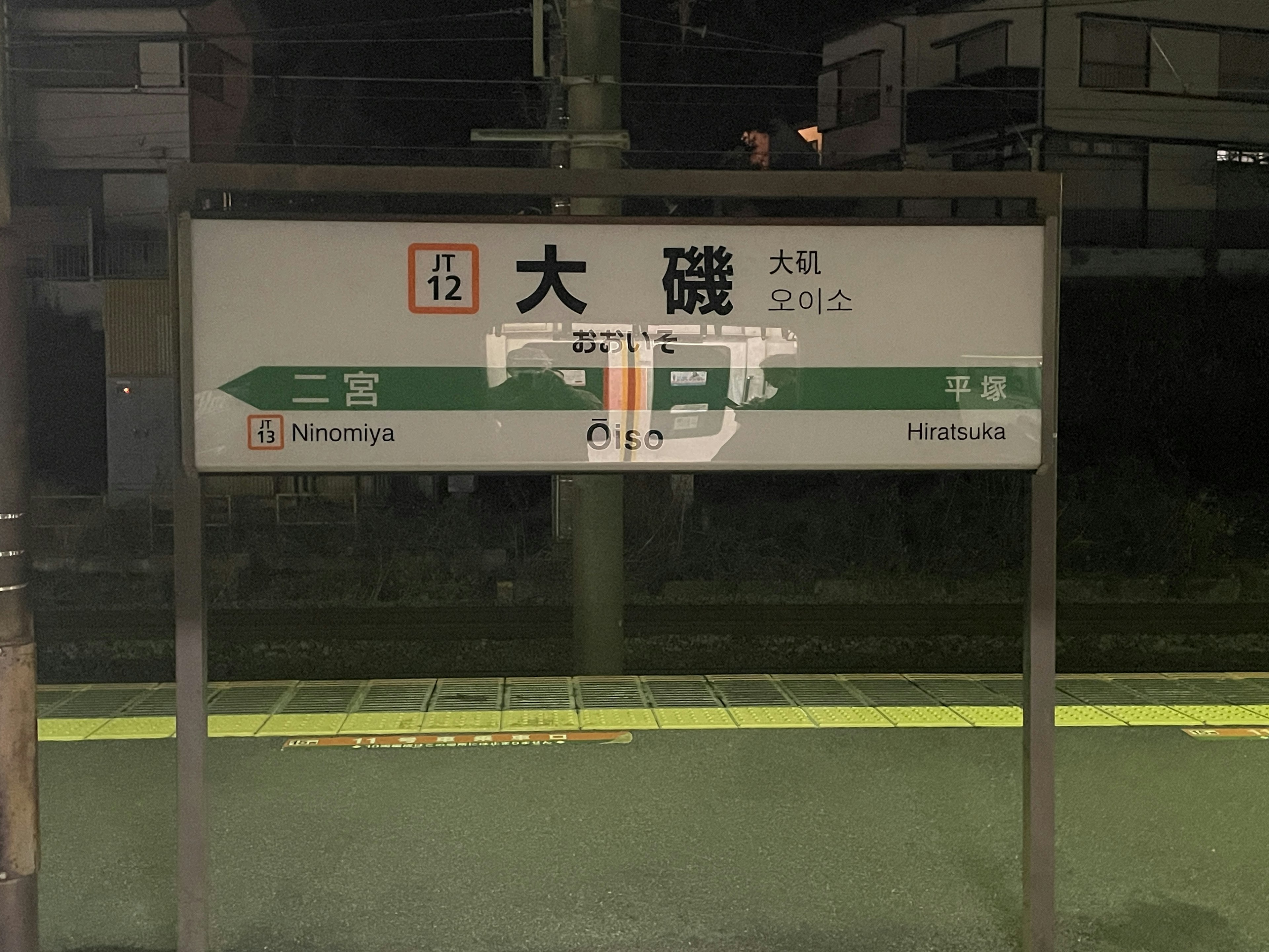 Sign of Oiso Station illuminated at night