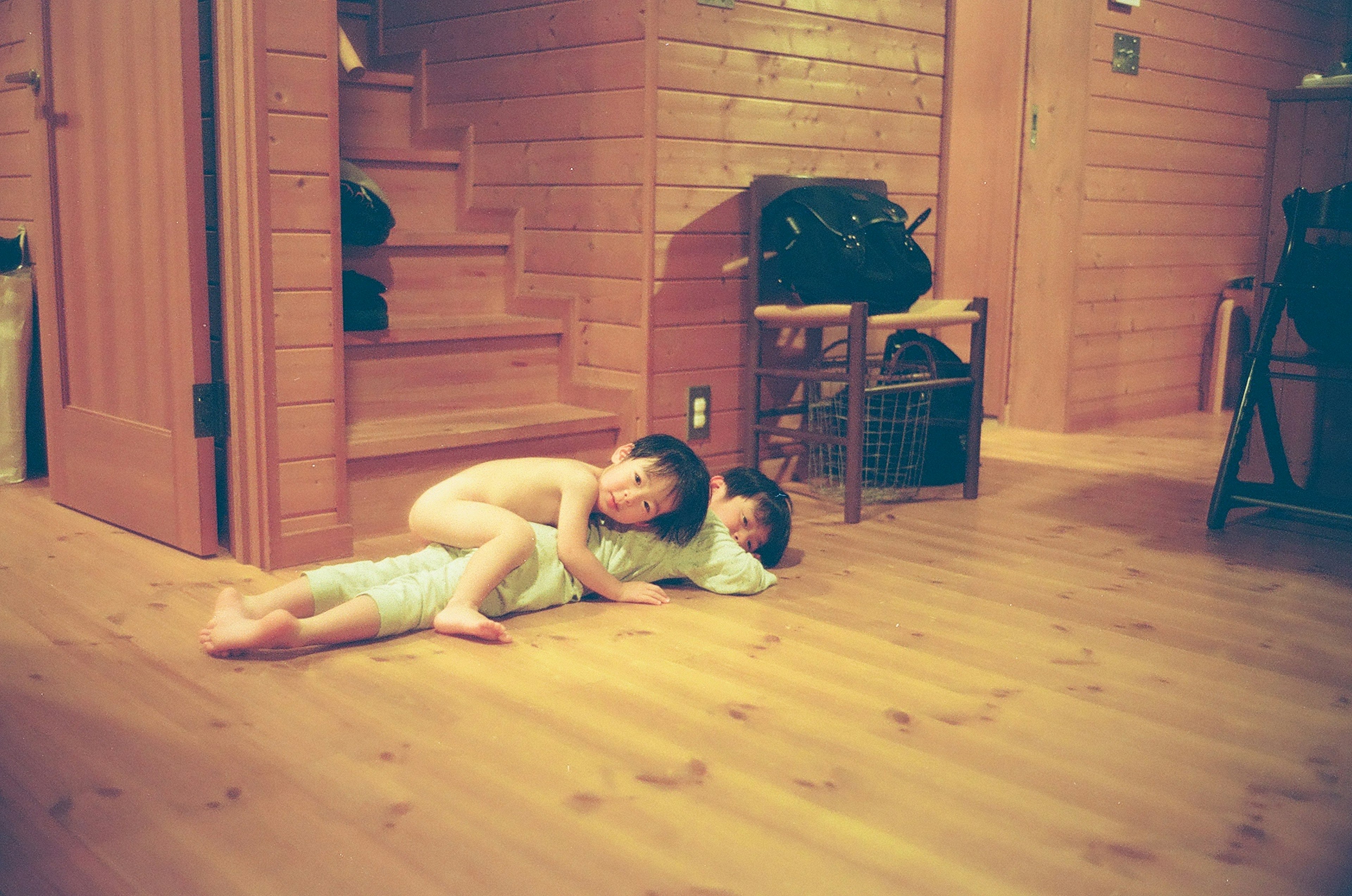 Two children playing on a wooden floor