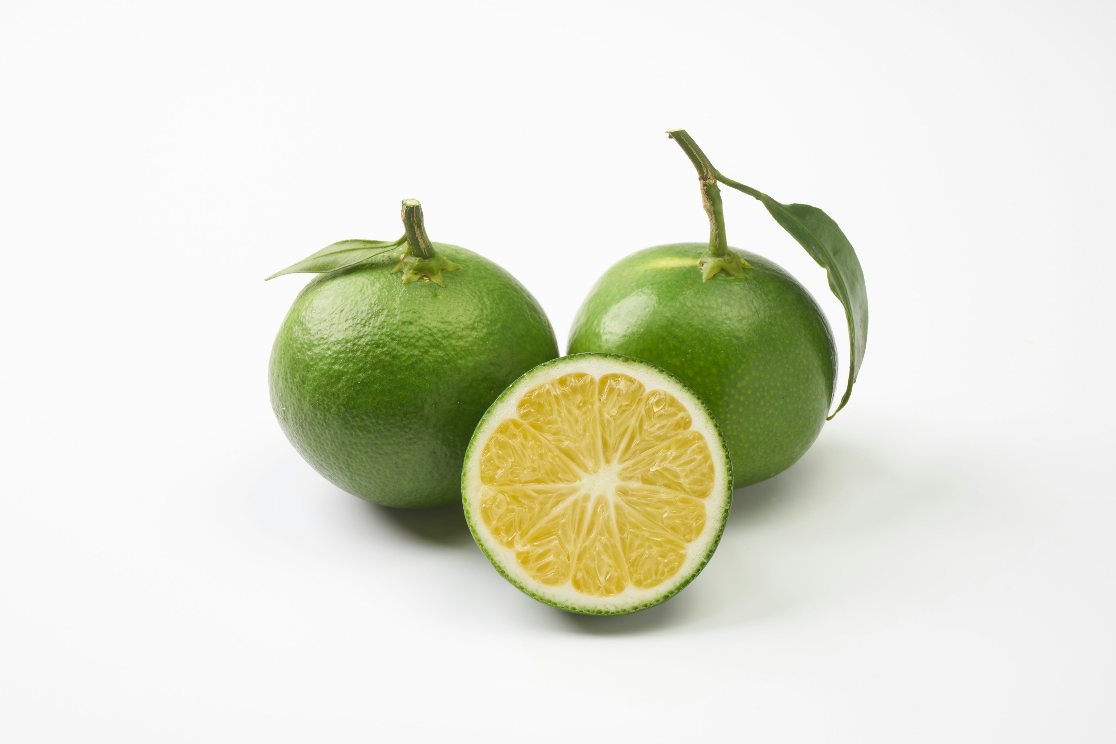 Image of green oranges with one cut in half