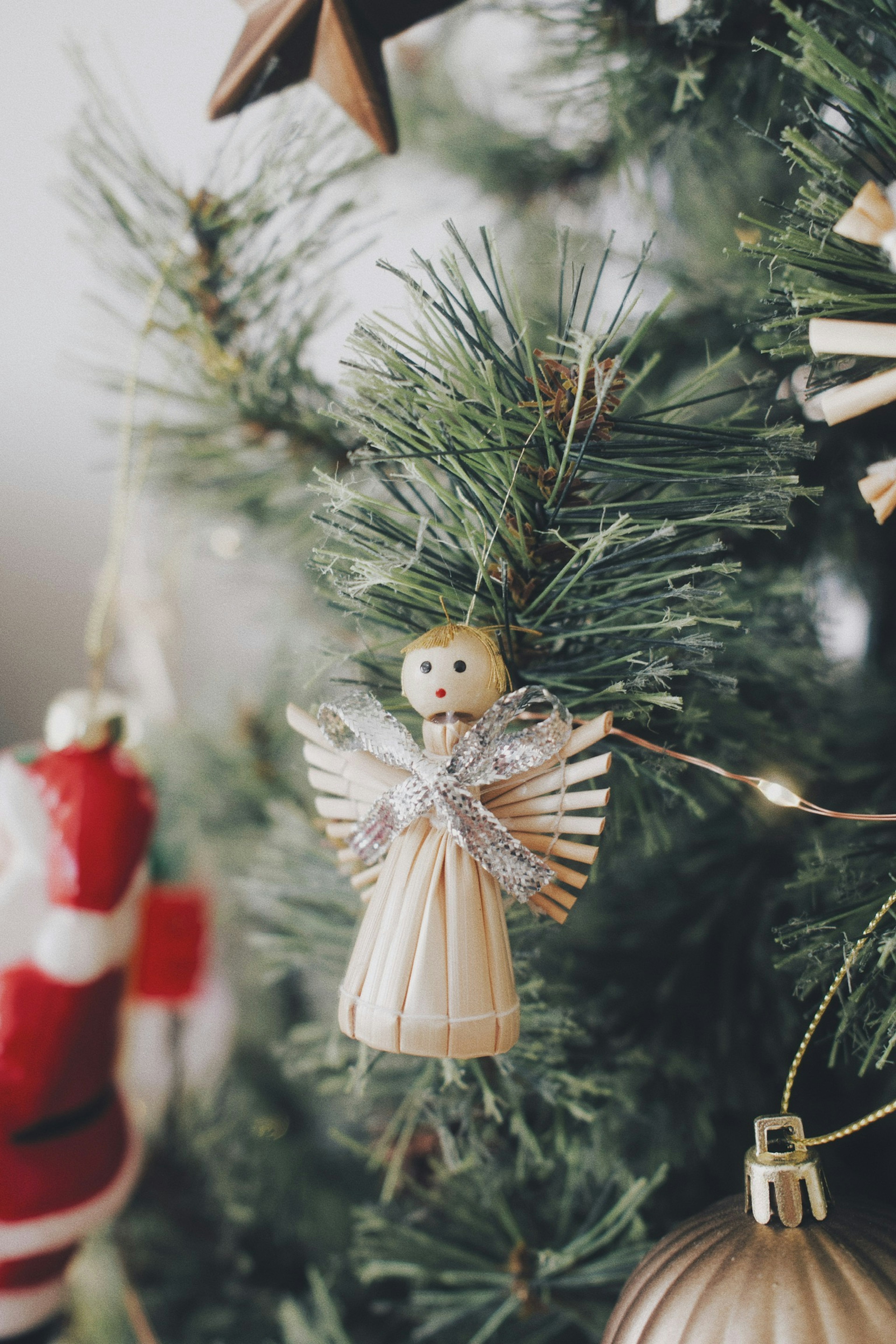 Árbol de Navidad decorado con un pequeño adorno de ángel de paja