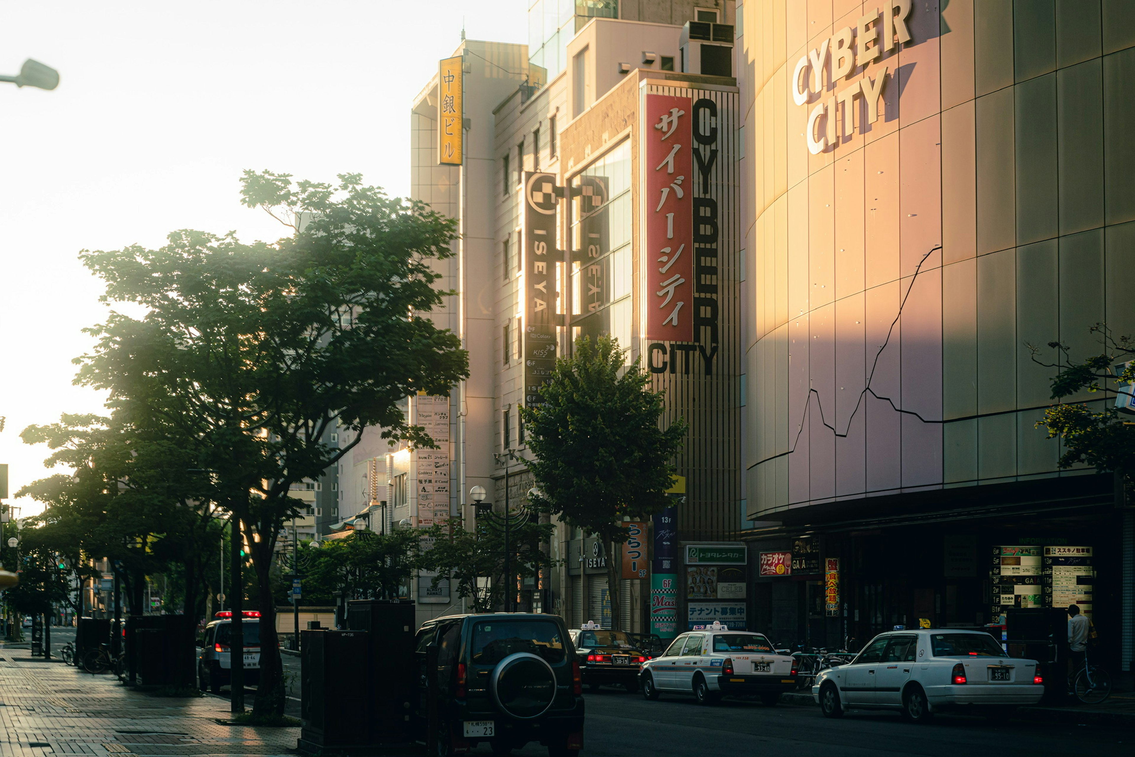 Escena urbana con letrero de Cyber City y luz del atardecer