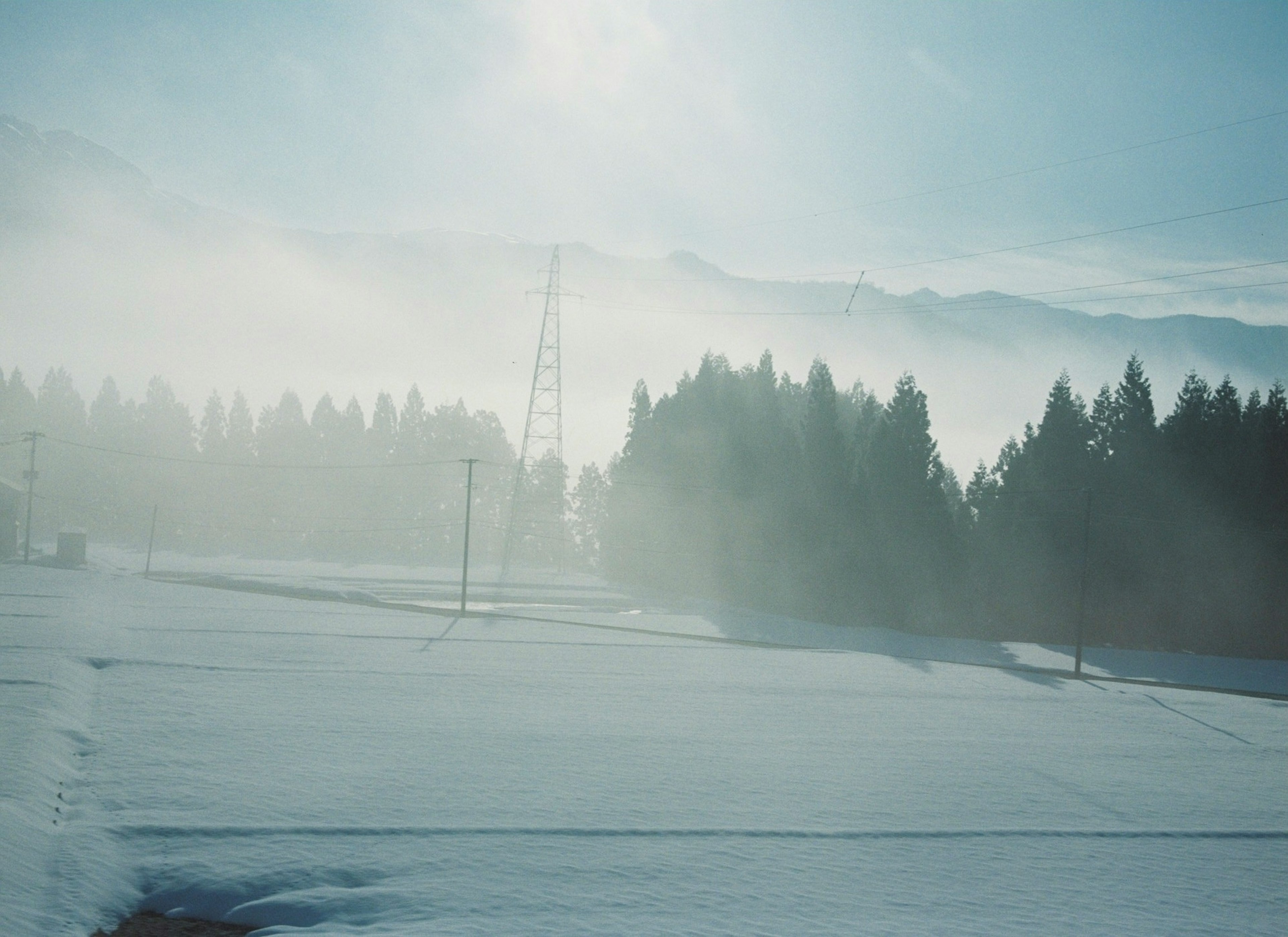 Snow-covered landscape with misty mountains in the background