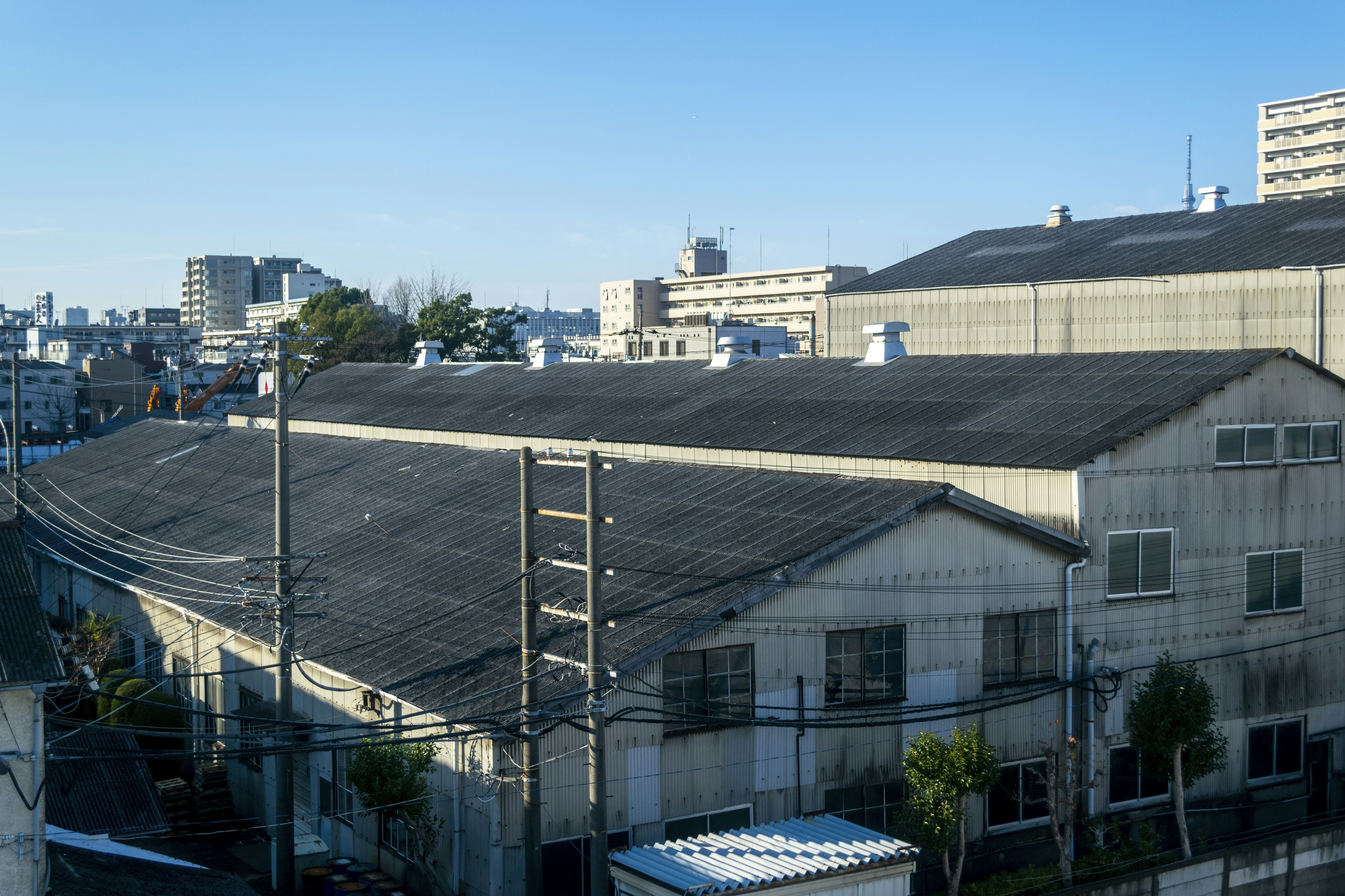 Urban landscape featuring a factory roof and surrounding buildings