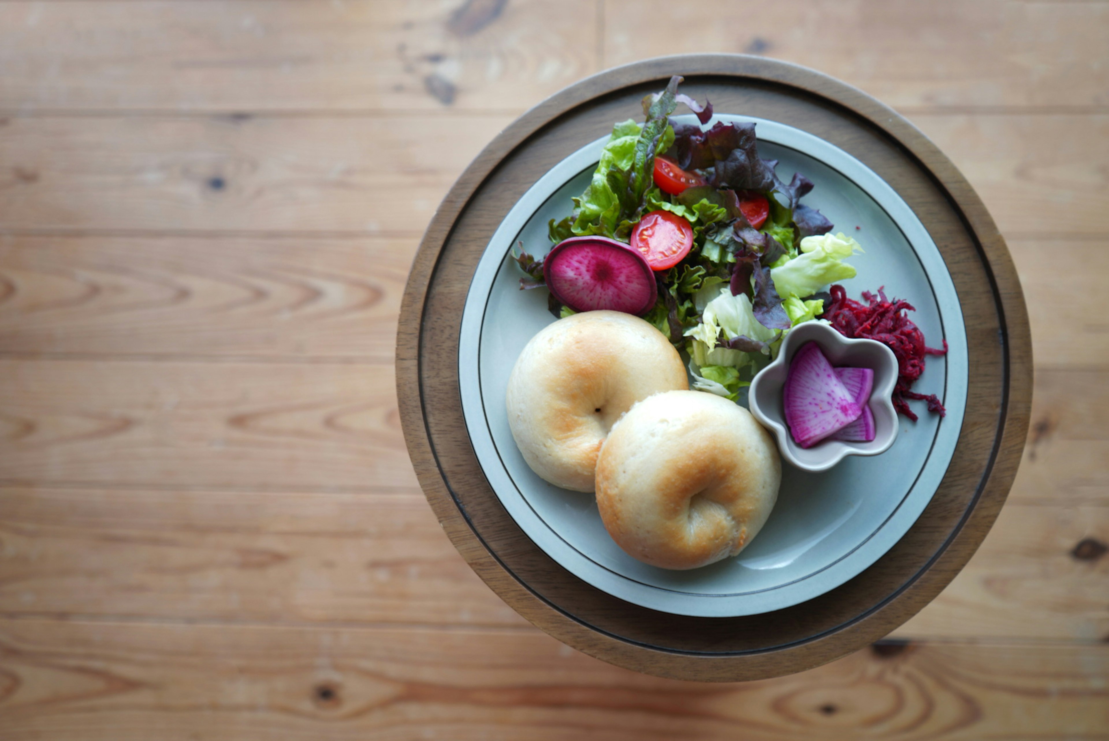 A top view of a plate with salad and two buns