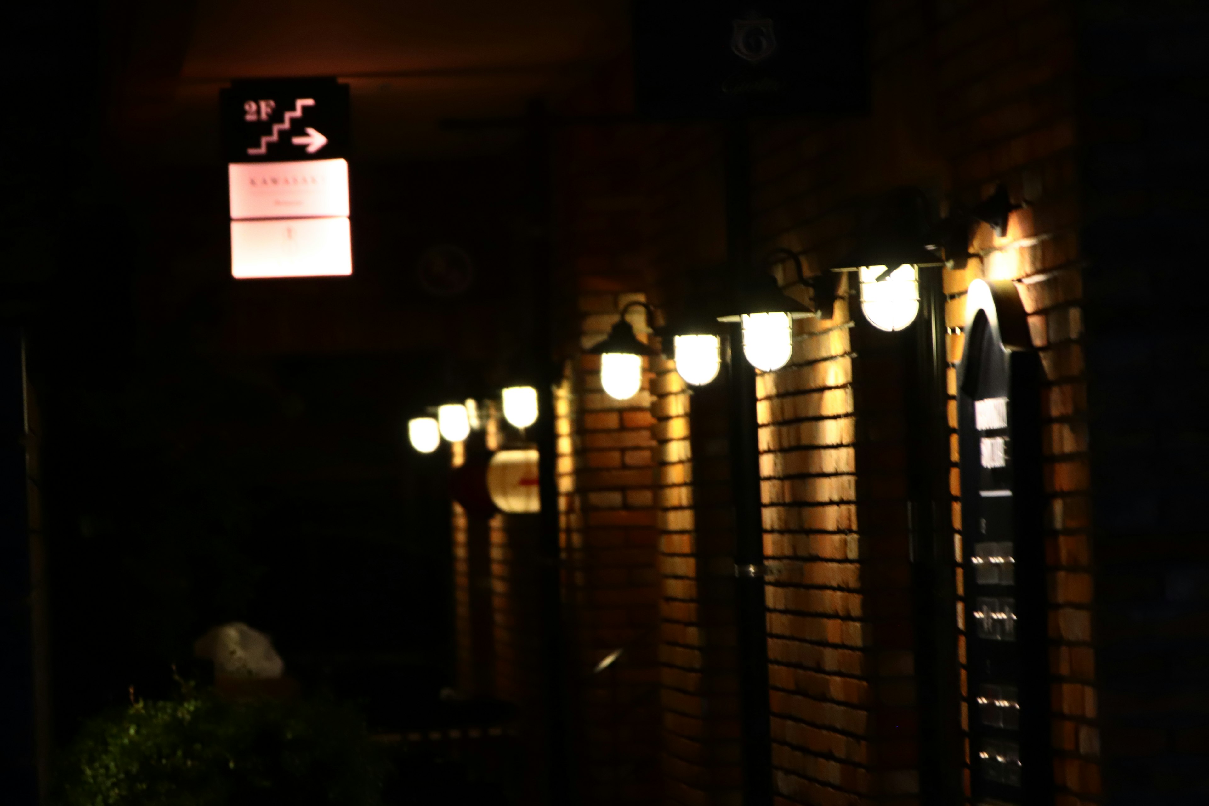 Warme Lichter entlang einer dunklen Straße mit einem roten Schild