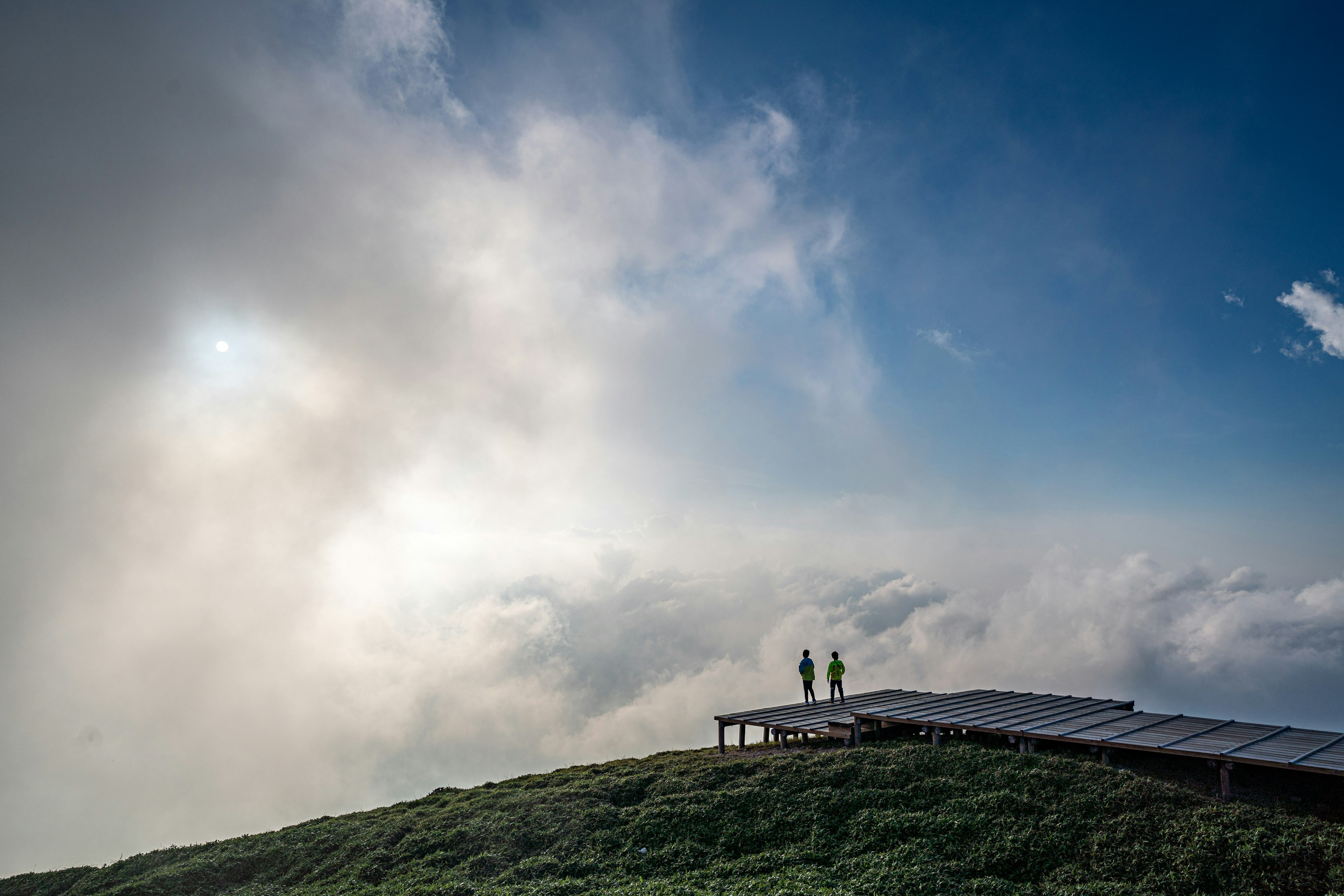 雲の上に立つ二人の人間と青い空の風景