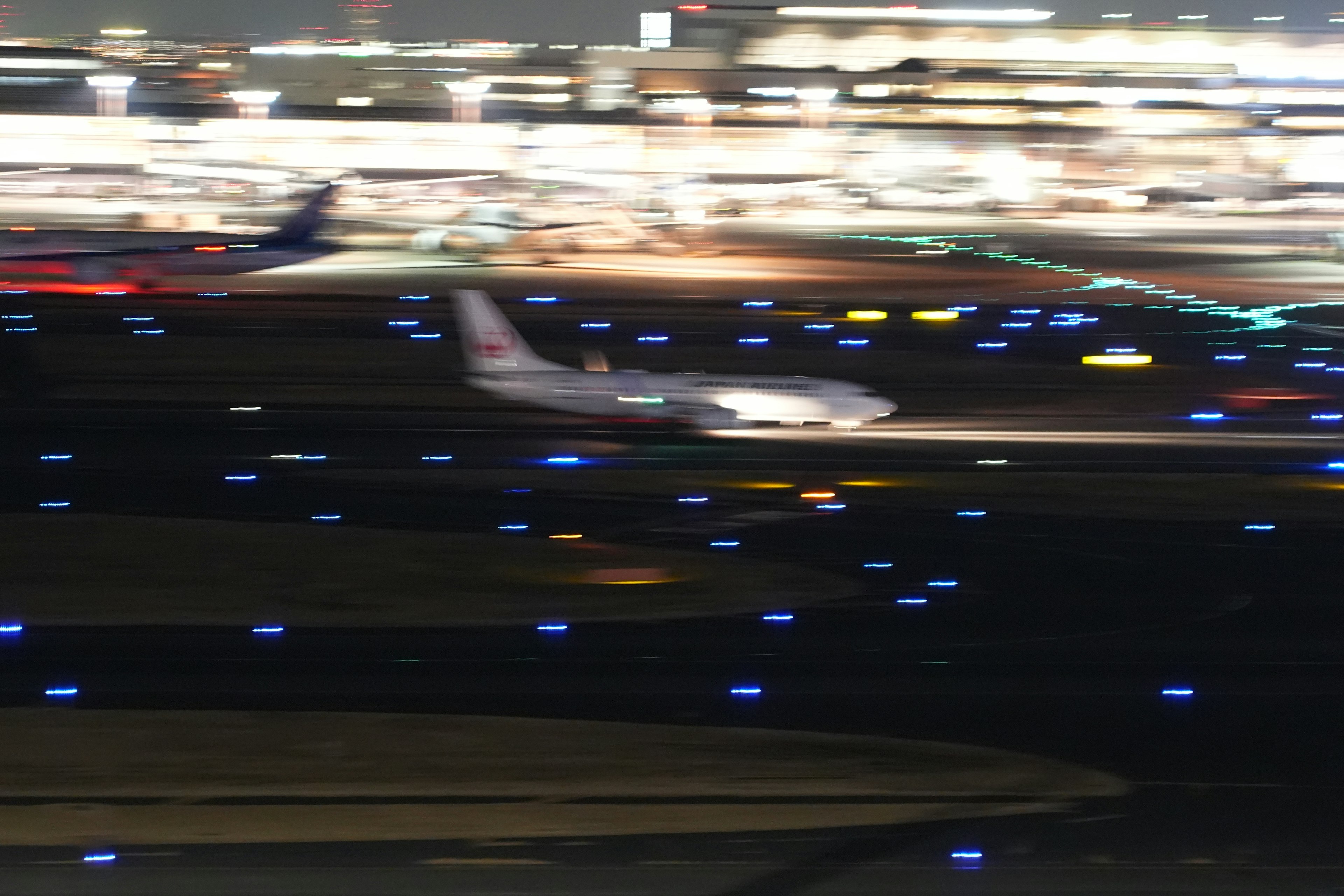 An airplane landing at night with illuminated runway lights