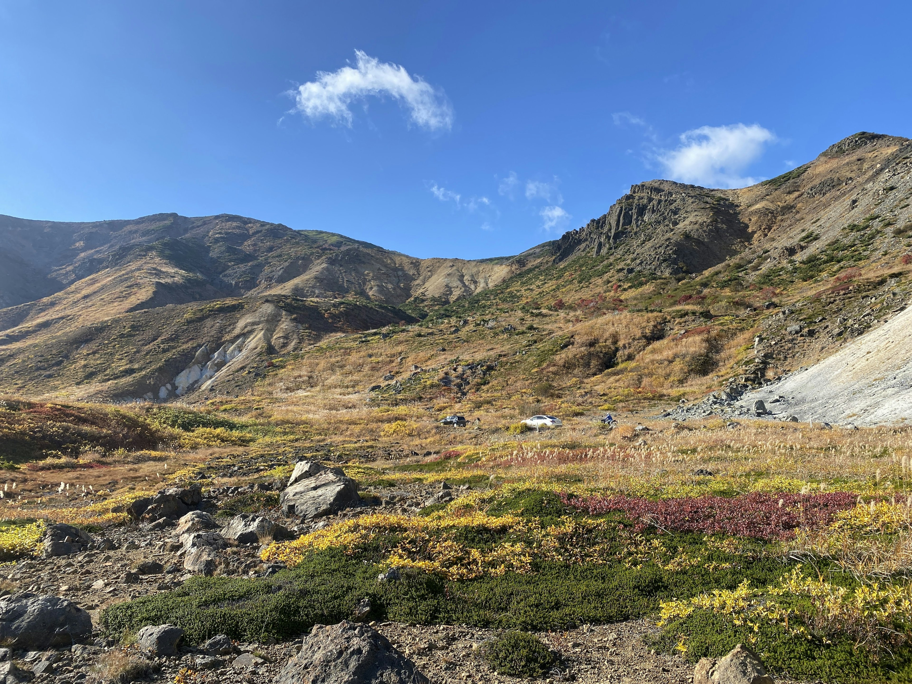 美しい秋の風景で、色とりどりの草原と山々が広がっている