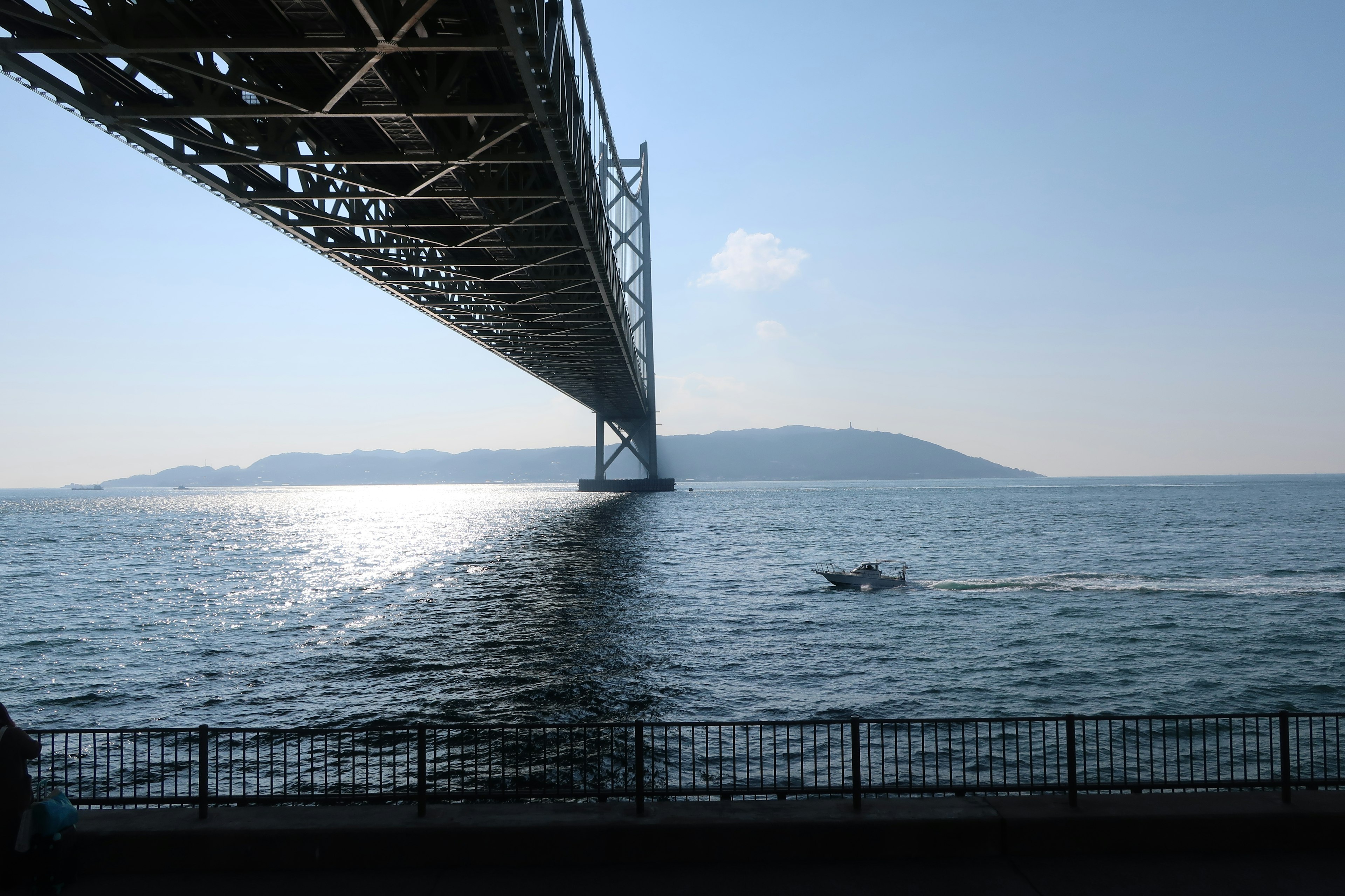 Vista panoramica di un ponte su acqua blu con un'isola in lontananza