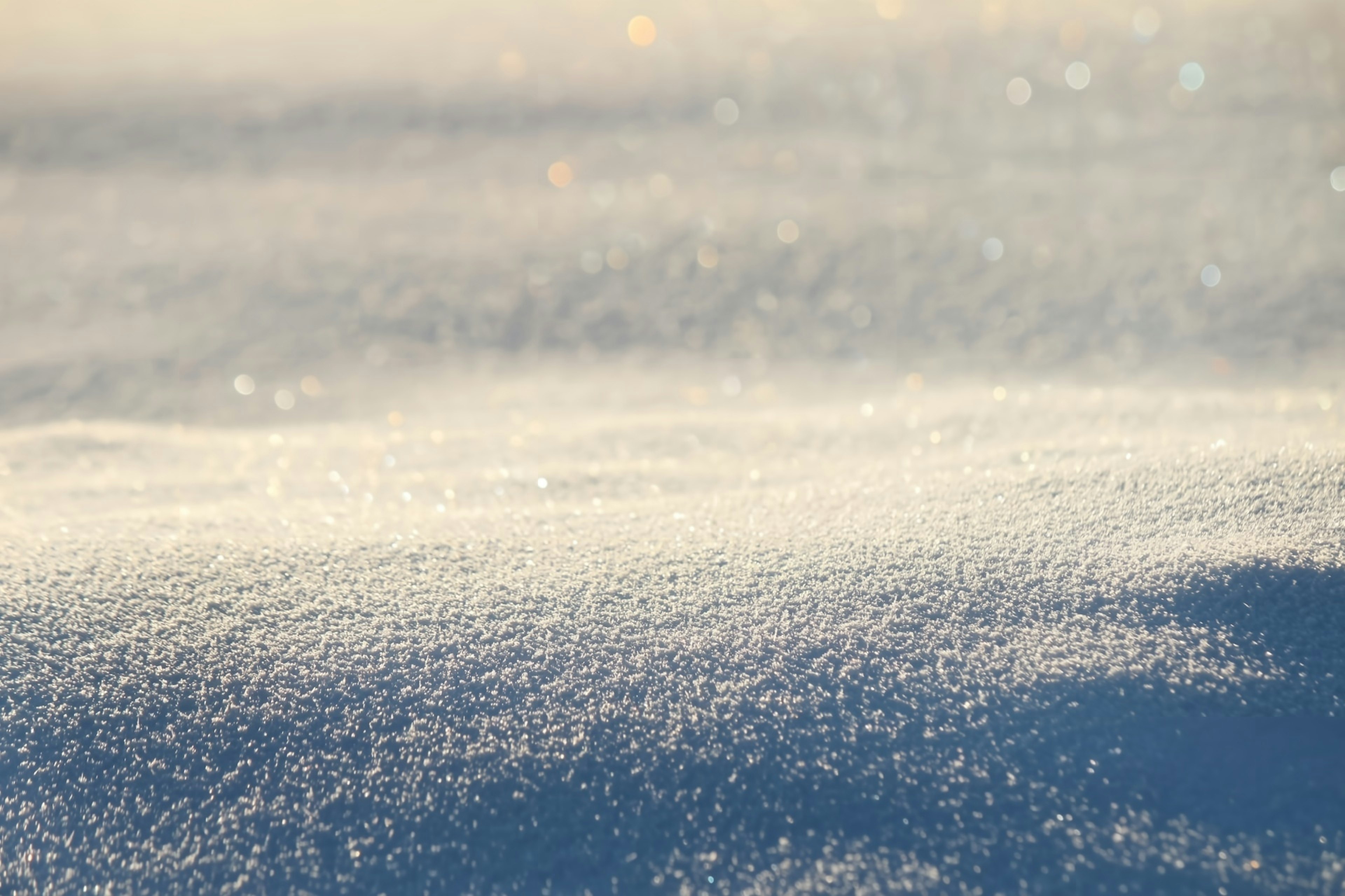 雪の上に広がる光沢のある白い結晶と輝く粒子