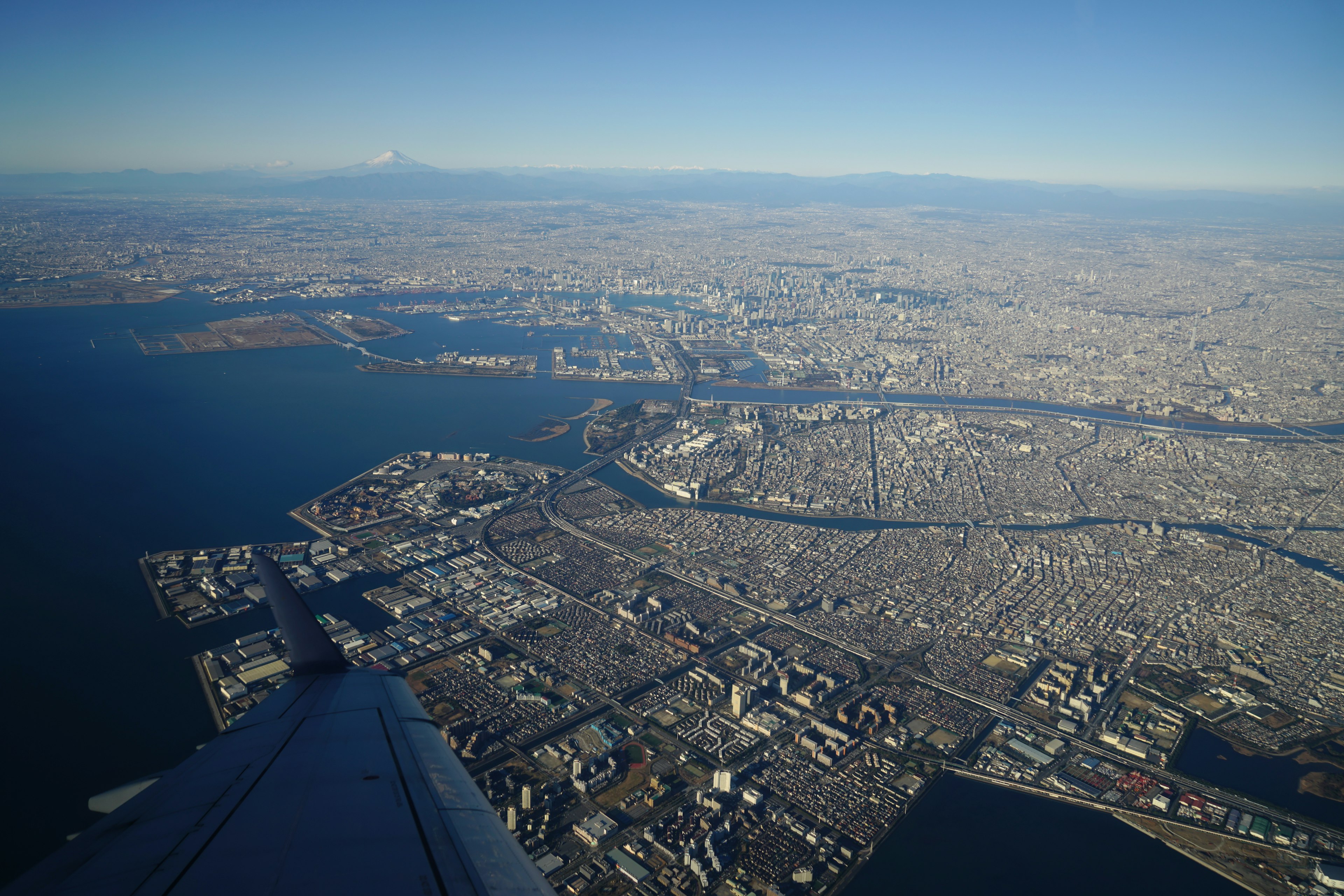 Aerial view of a sprawling city and coastline from an airplane