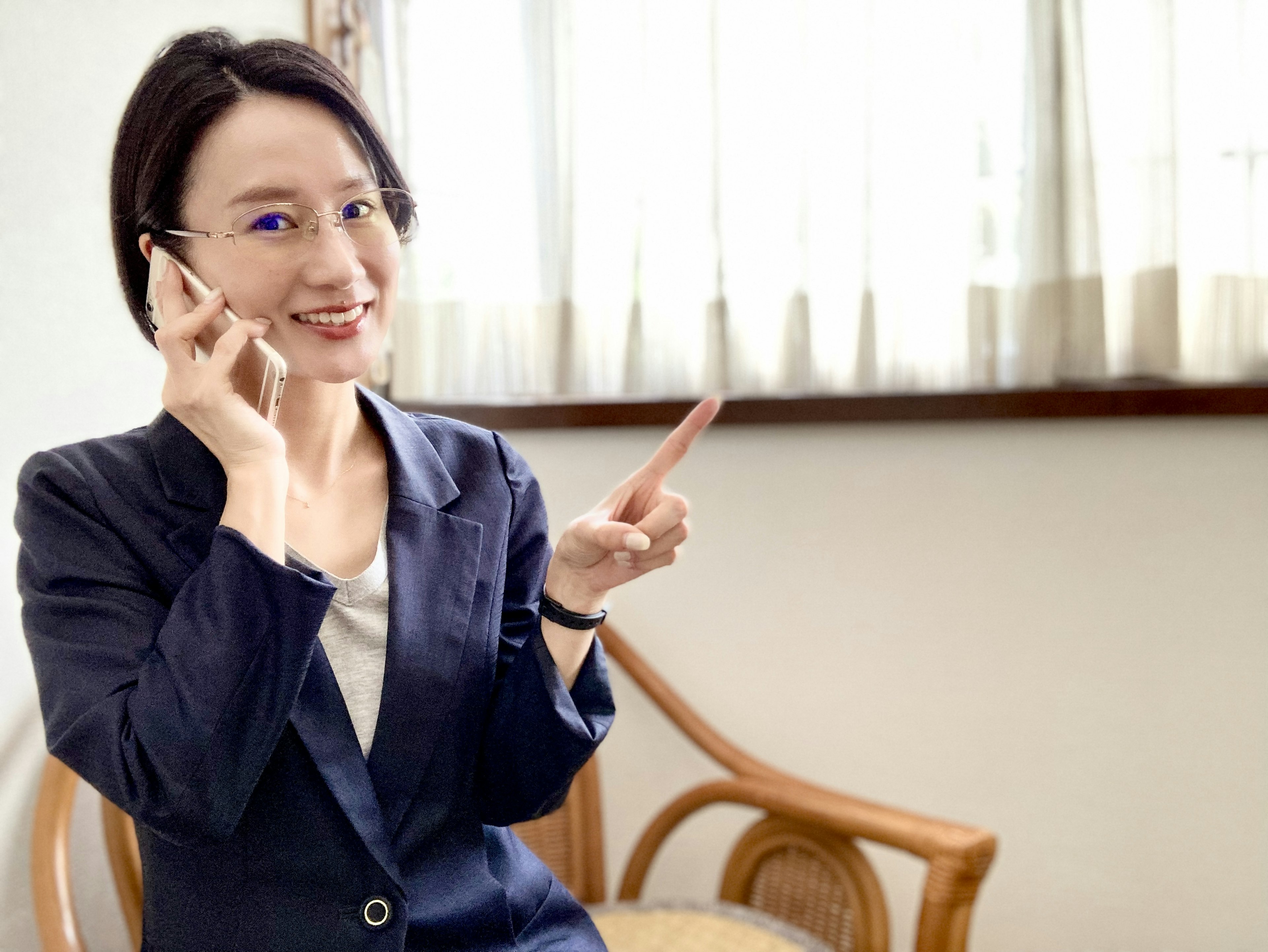 Donna sorridente al telefono che indica con un dito