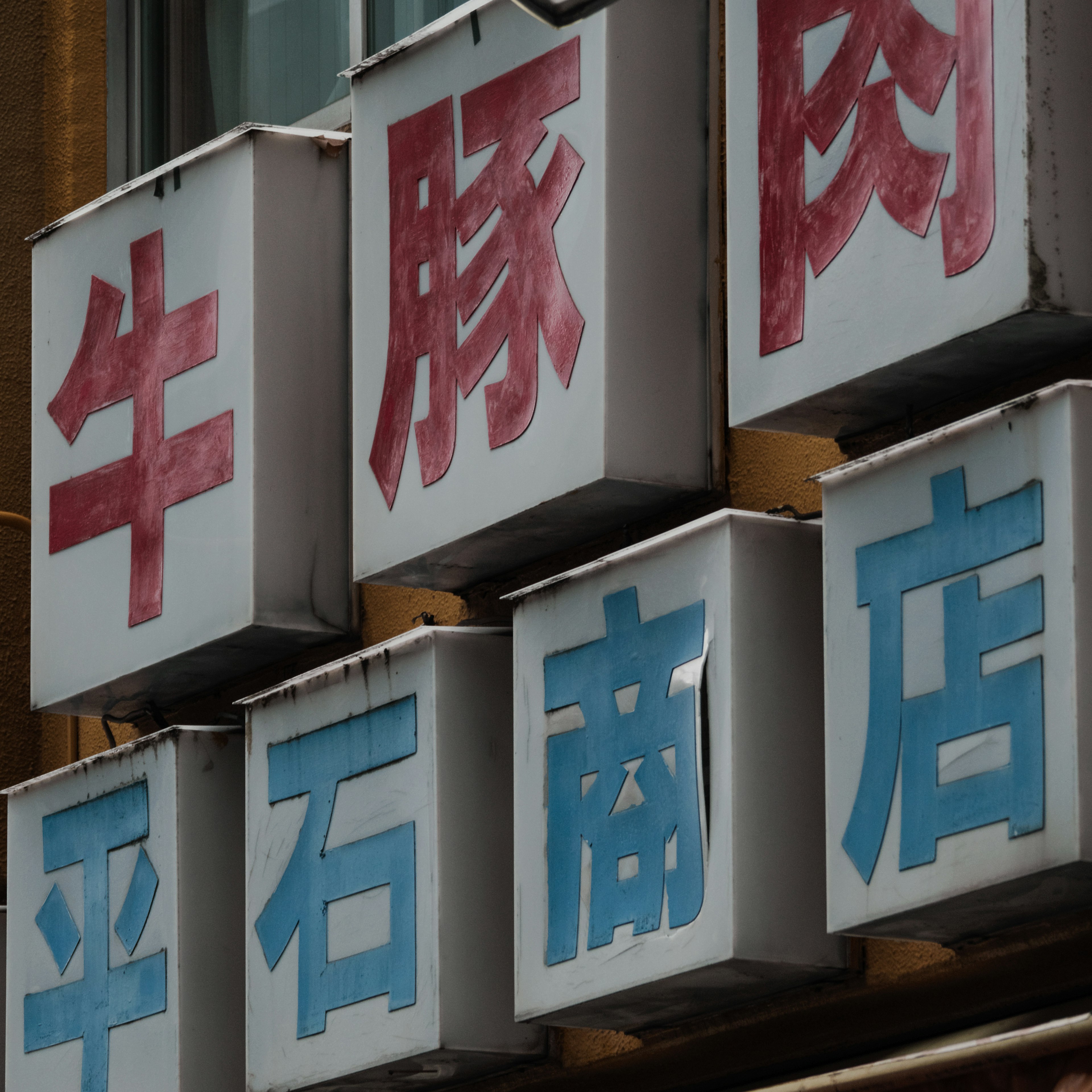 Signboard of a meat shop featuring red and blue letters