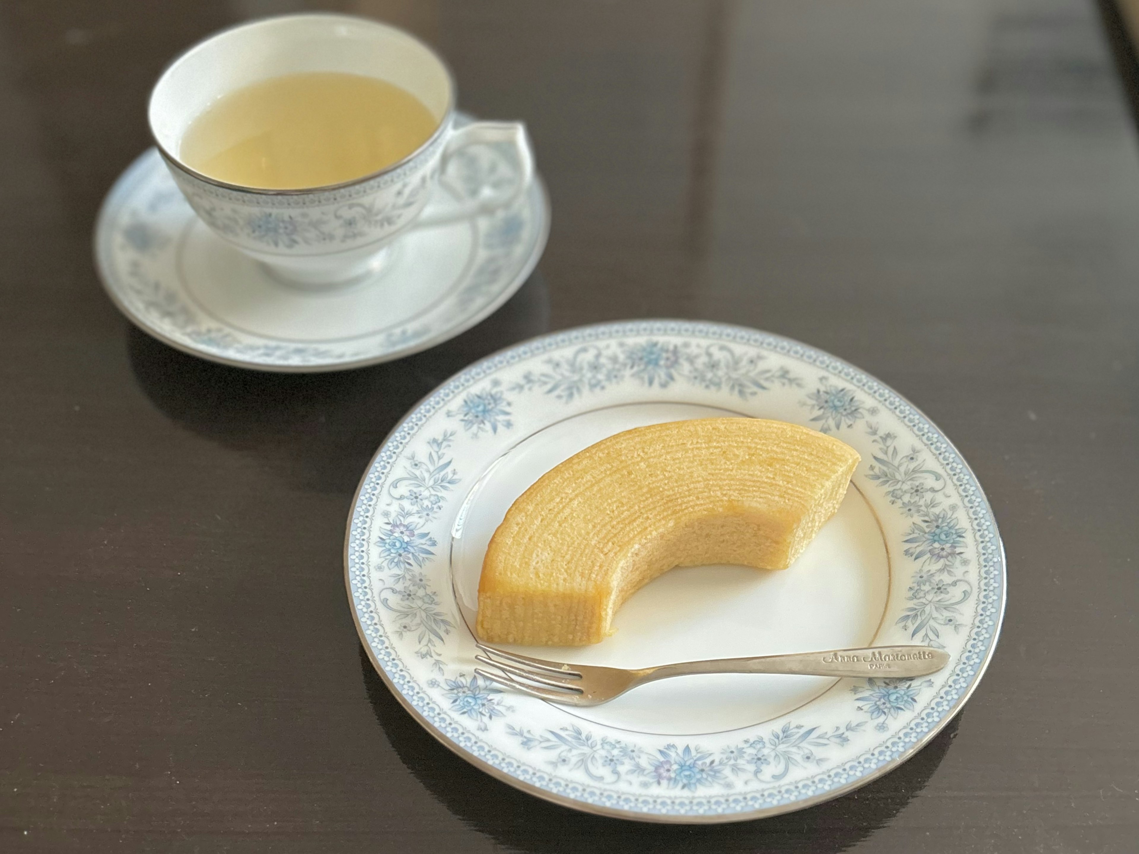 A slice of Baumkuchen served with tea on a decorative plate