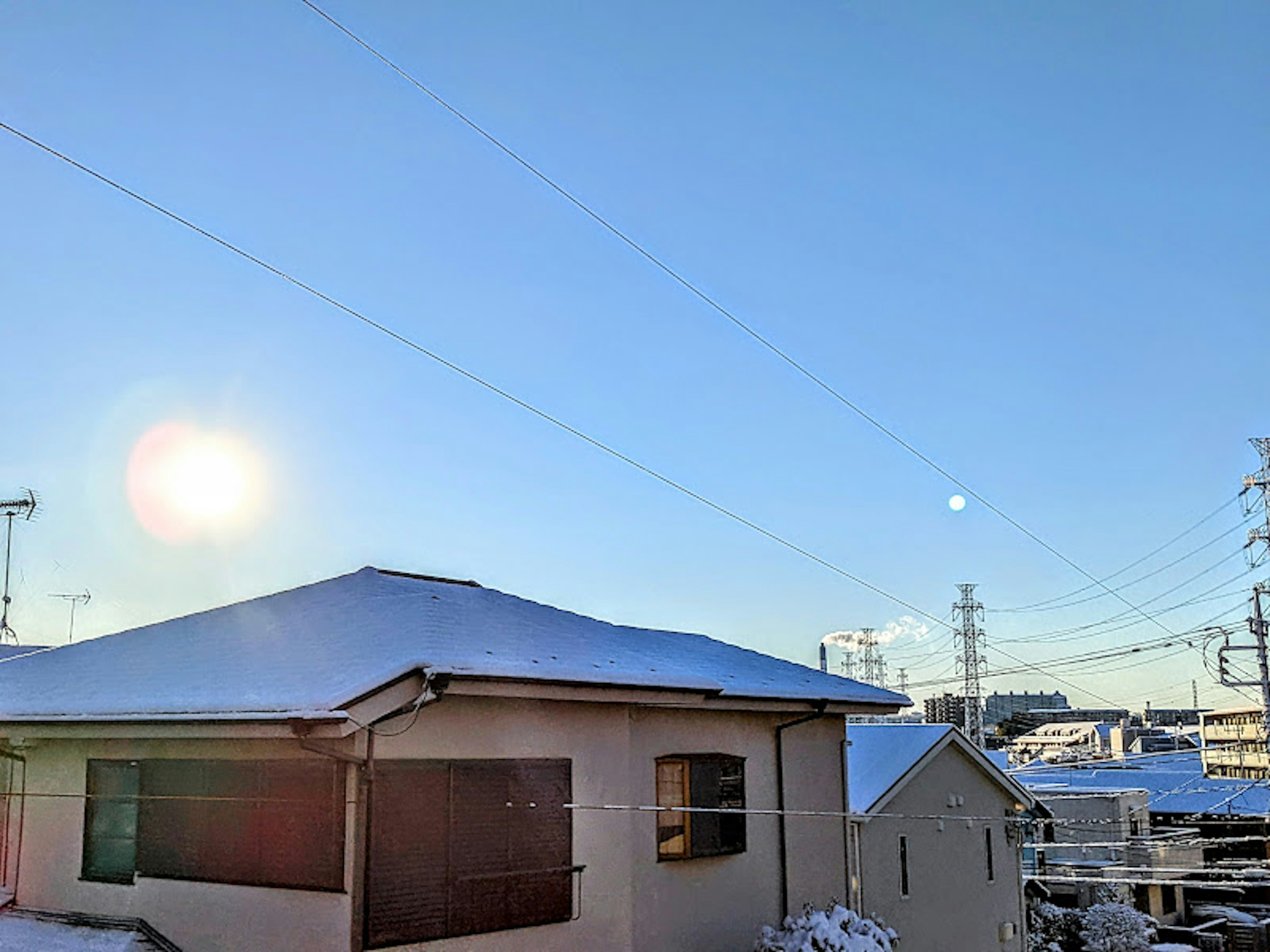 Ein Haus mit einem schneebedeckten Dach unter einem klaren blauen Himmel