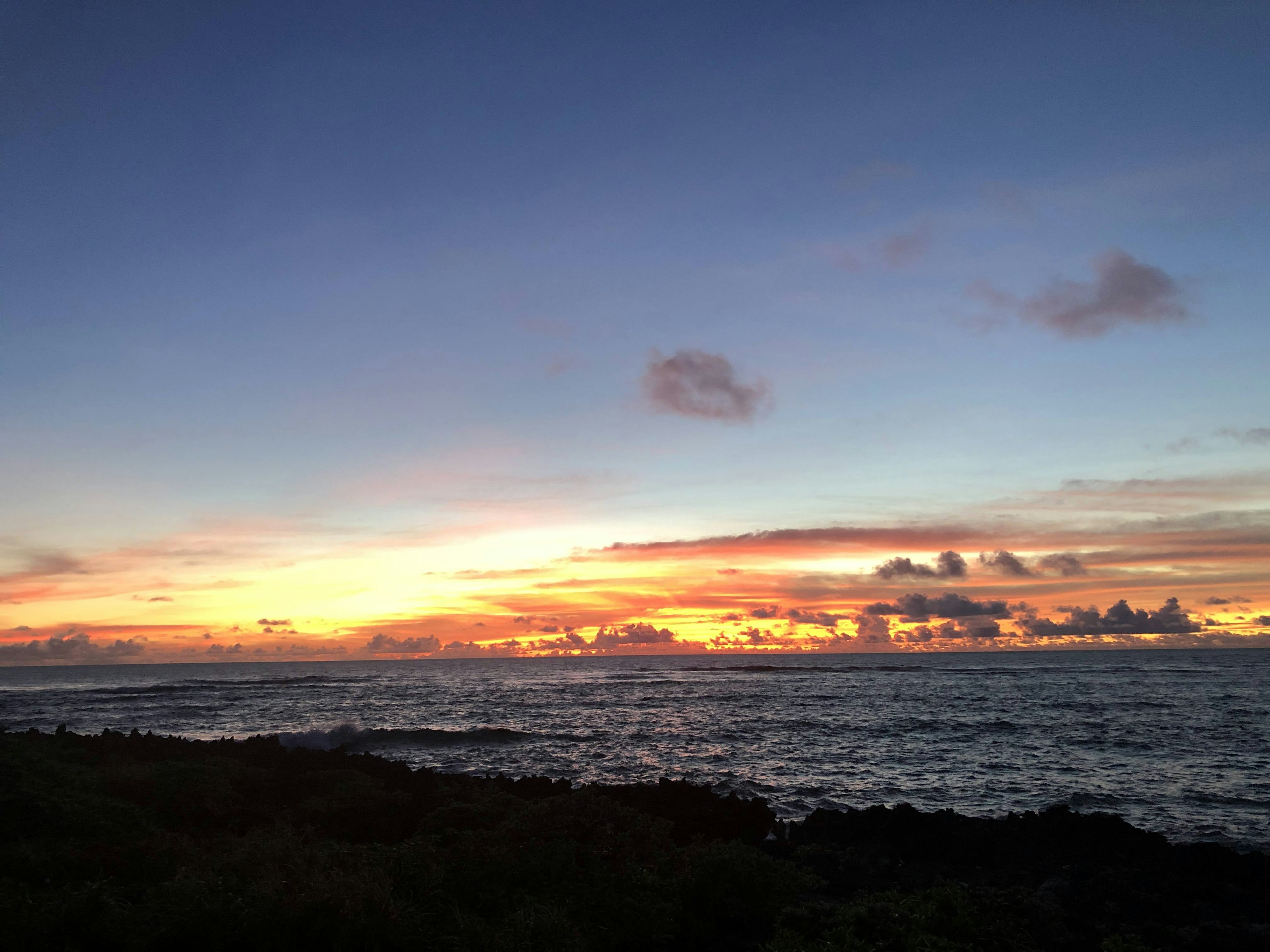 Senja pantai dengan ombak dan langit berwarna