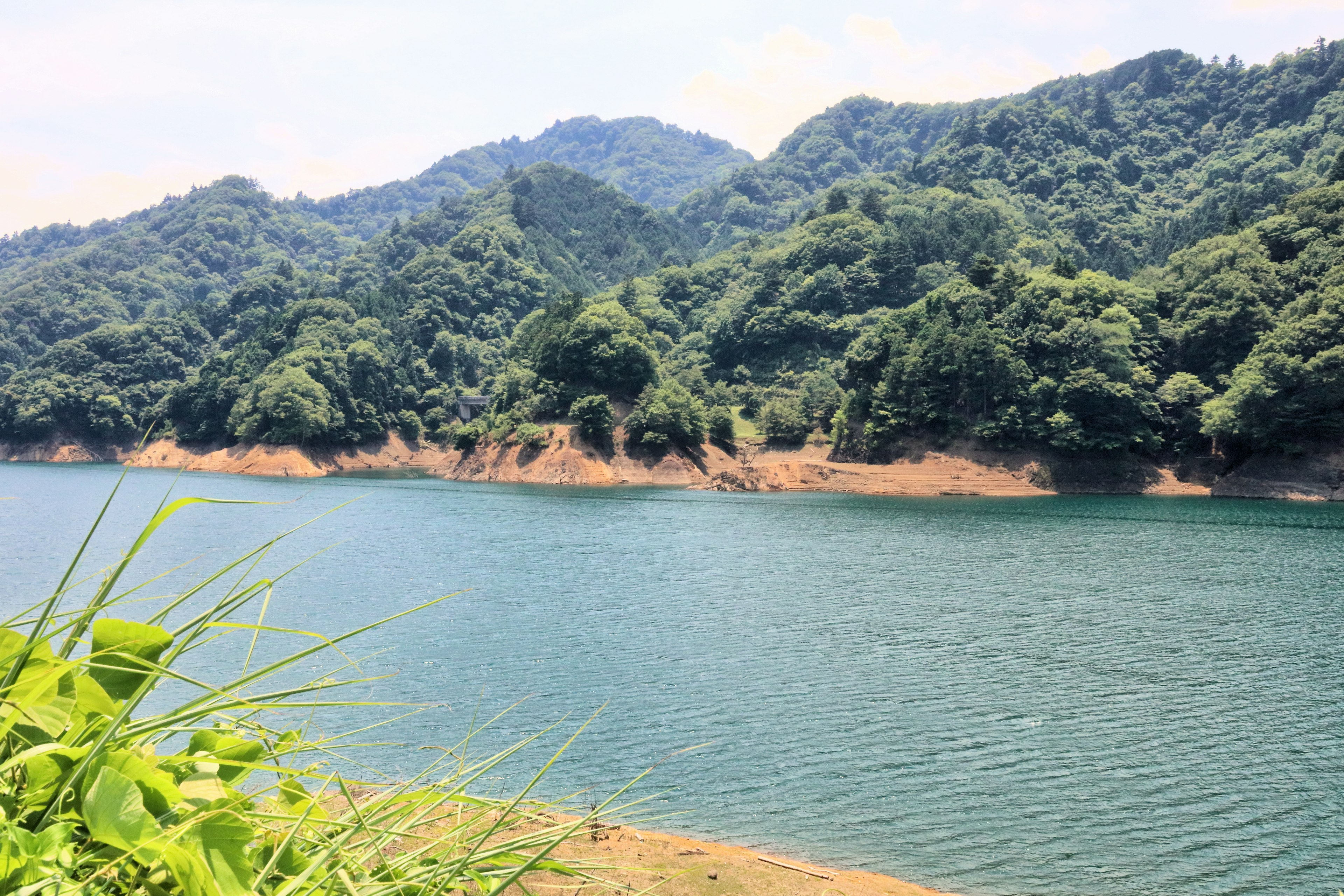 Vista escénica de montañas verdes y agua tranquila del lago